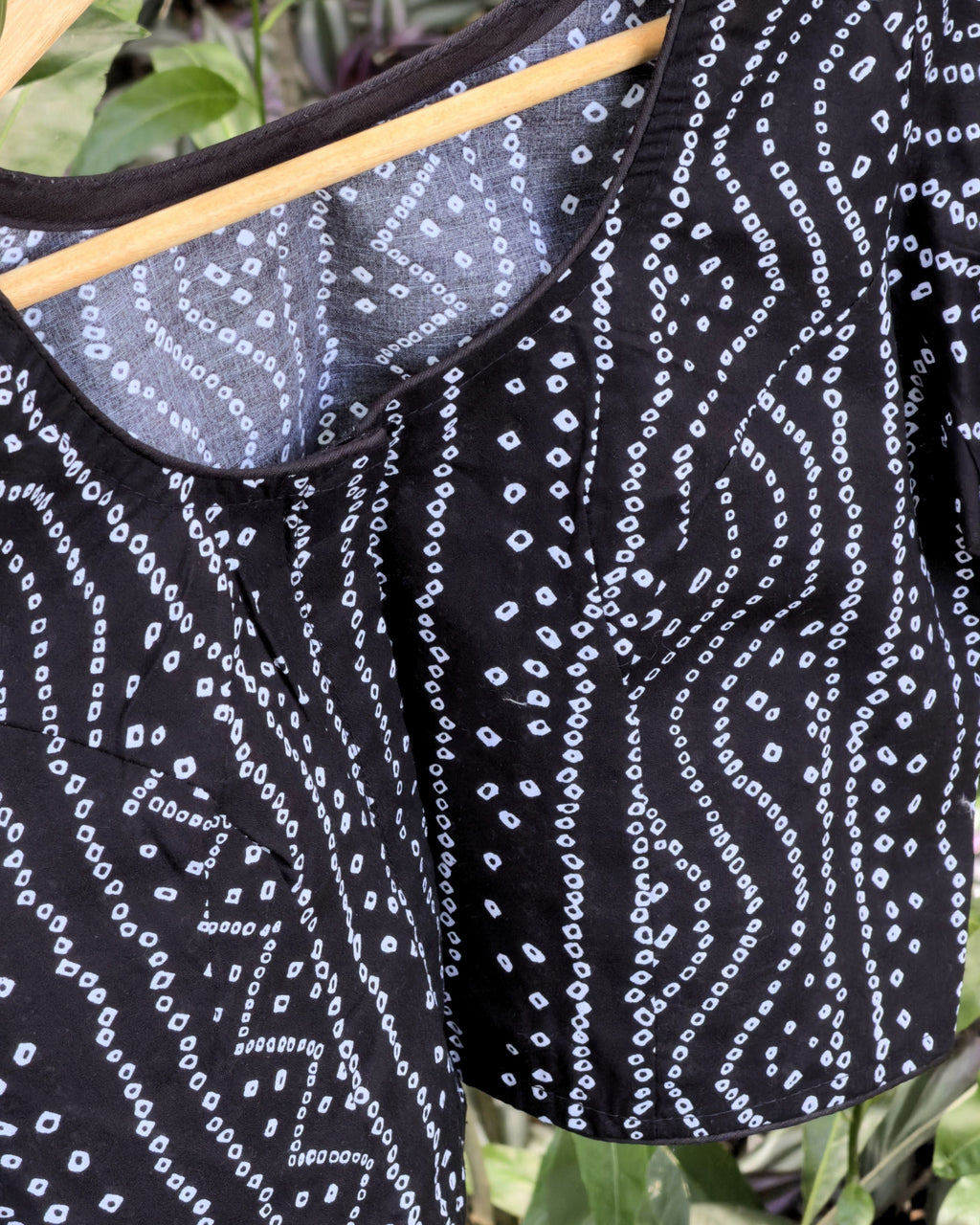 black bandhej blouse with round neckline and white dotted print