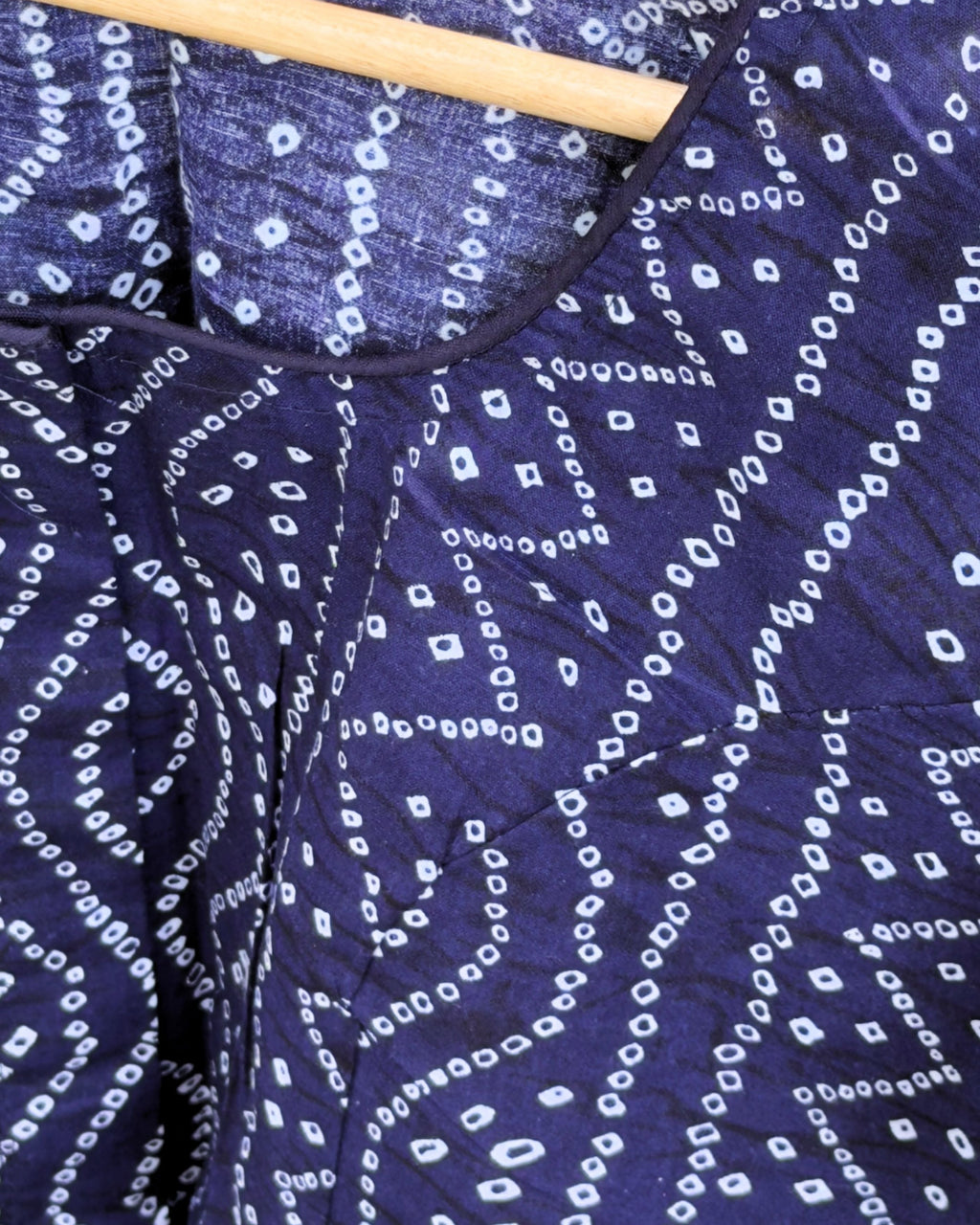 close up of blue cotton fabric with white bandhej geometric dotted print