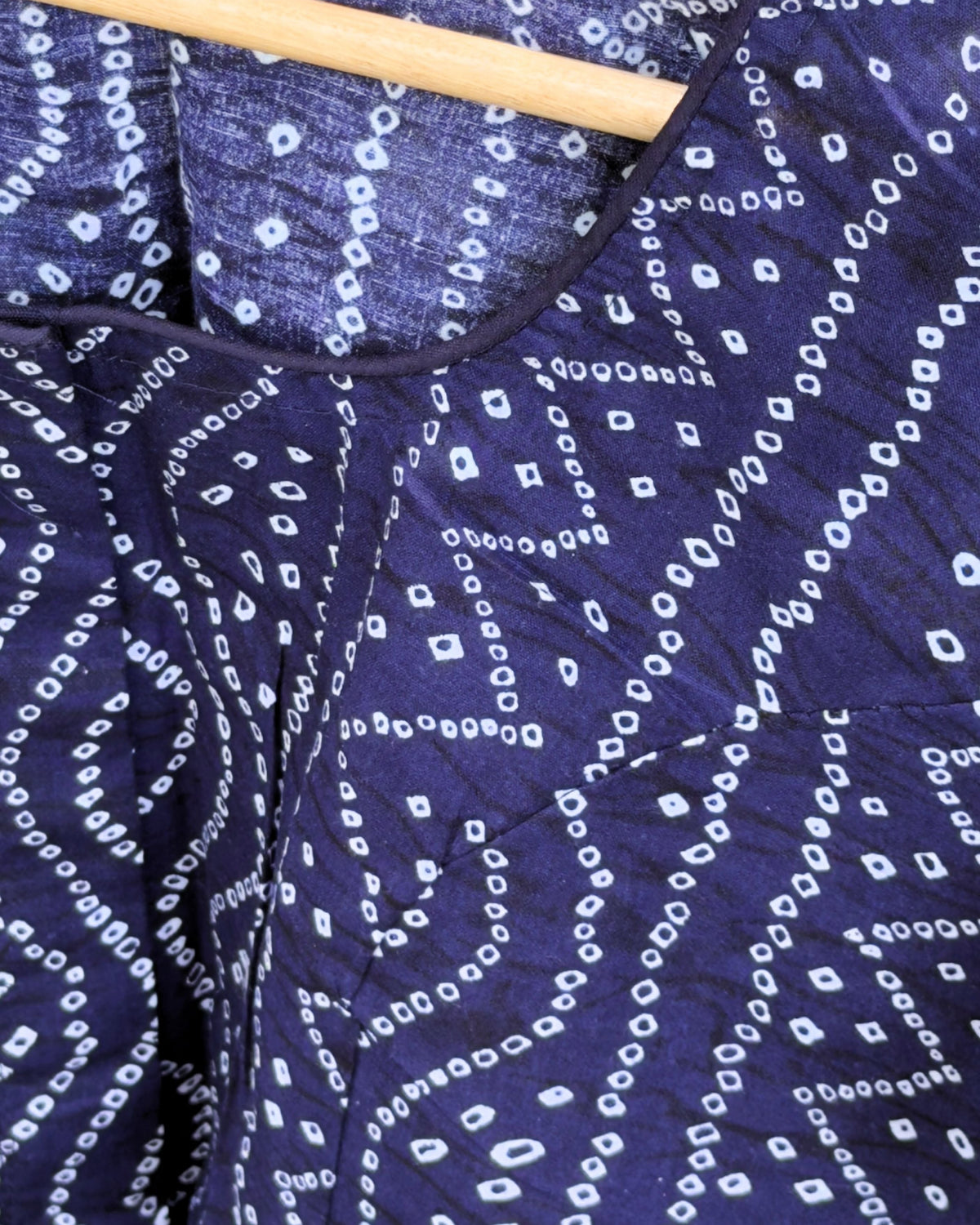 close up of blue cotton fabric with white bandhej geometric dotted print