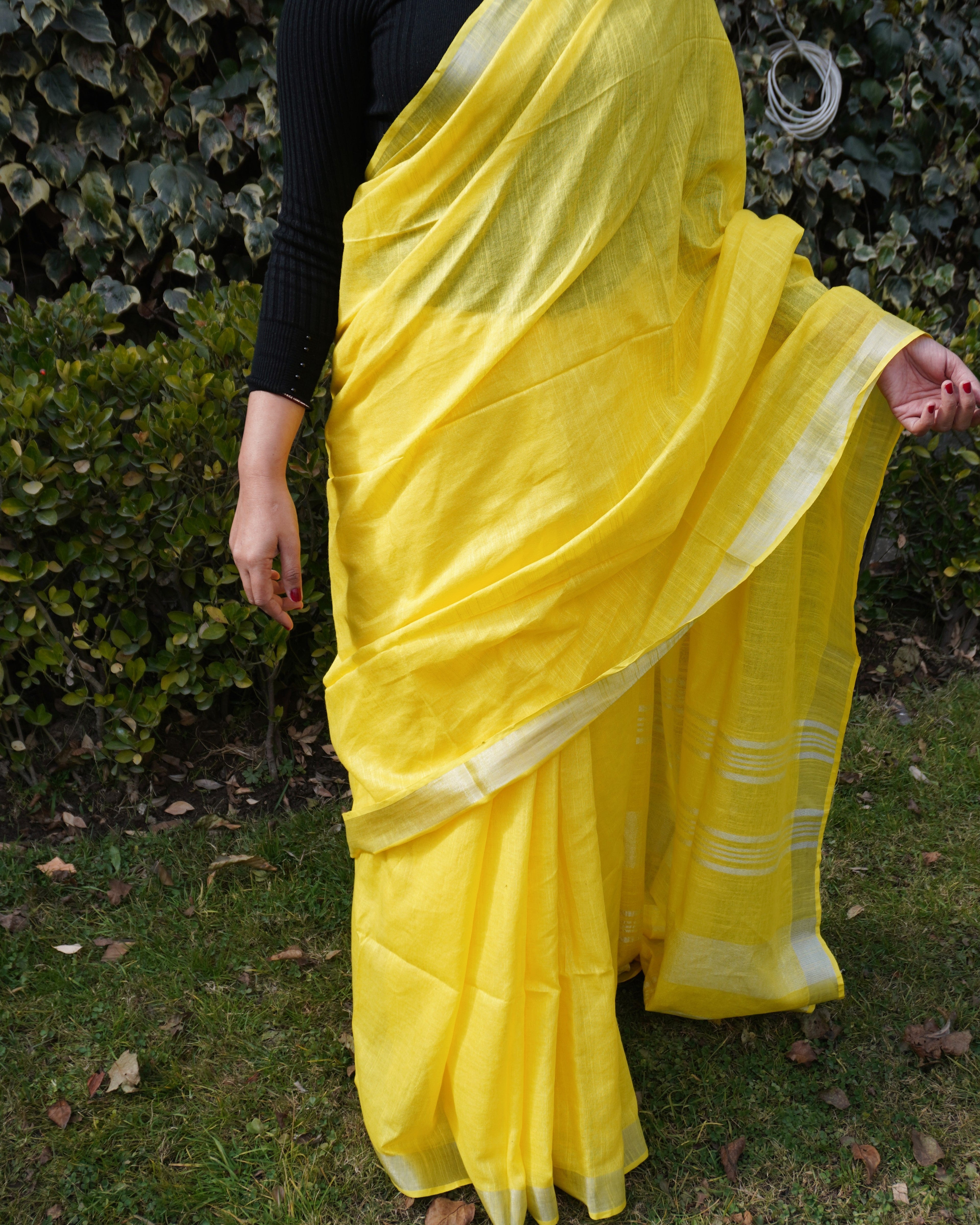 Close-up of bright yellow pure linen saree with zari border showing fine fabric texture and zari detailing