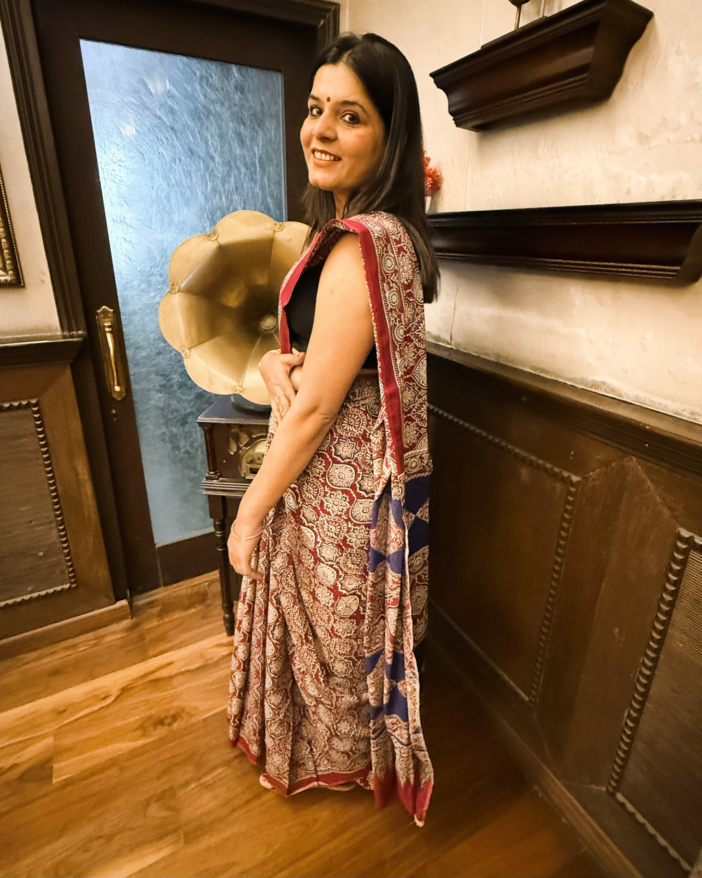 Side view of maroon and blue Ajrakh print mul cotton saree displaying soft drape flow and border detailing