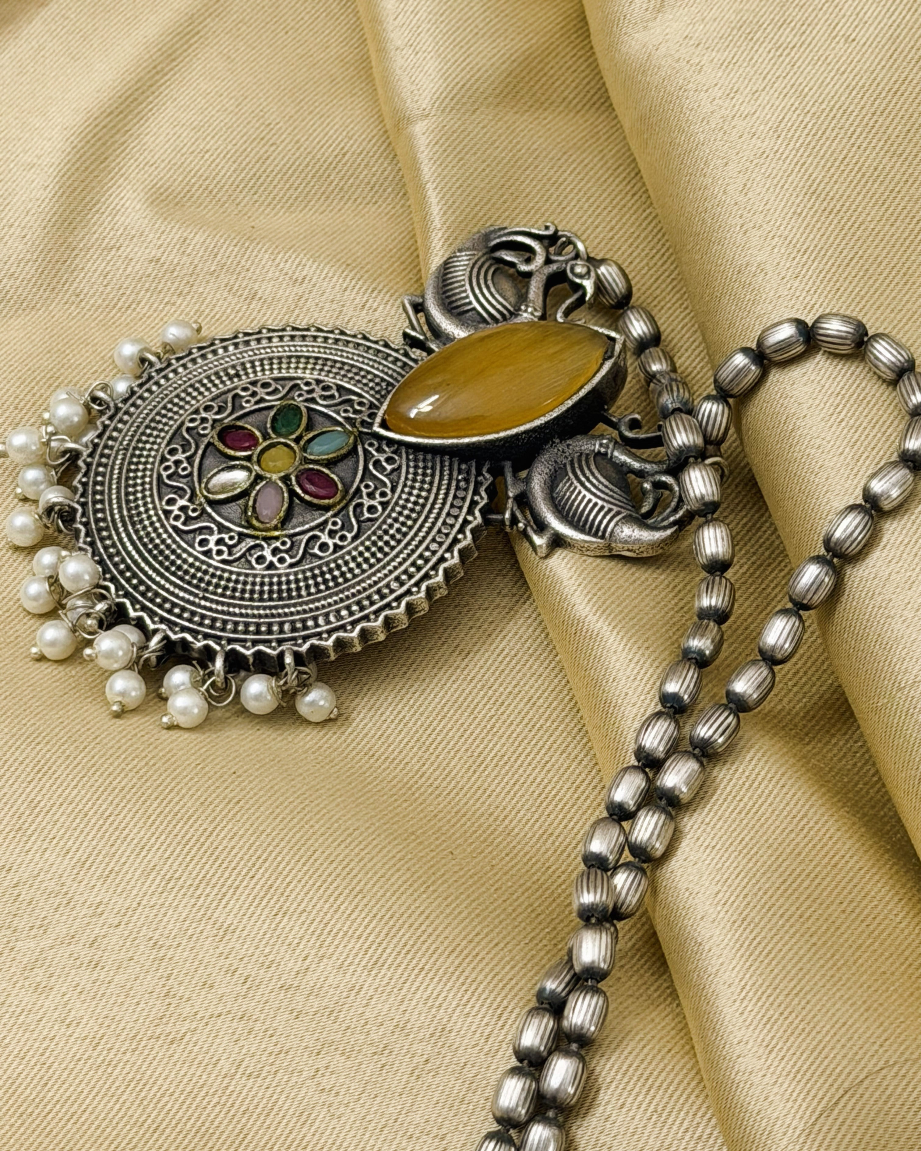 Complete display of necklace and earrings set in antique brass with intricate detailing and pearls