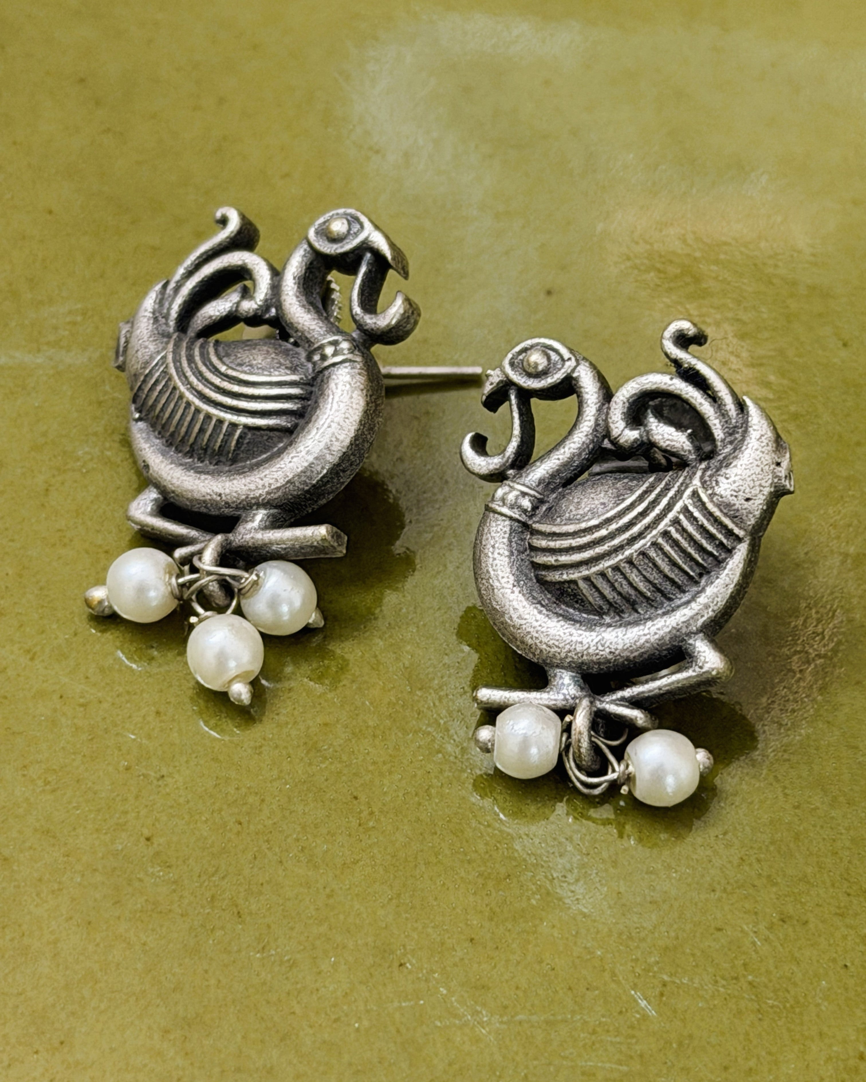 Matching brass peacock motif earrings with pearl drops in antique finish
