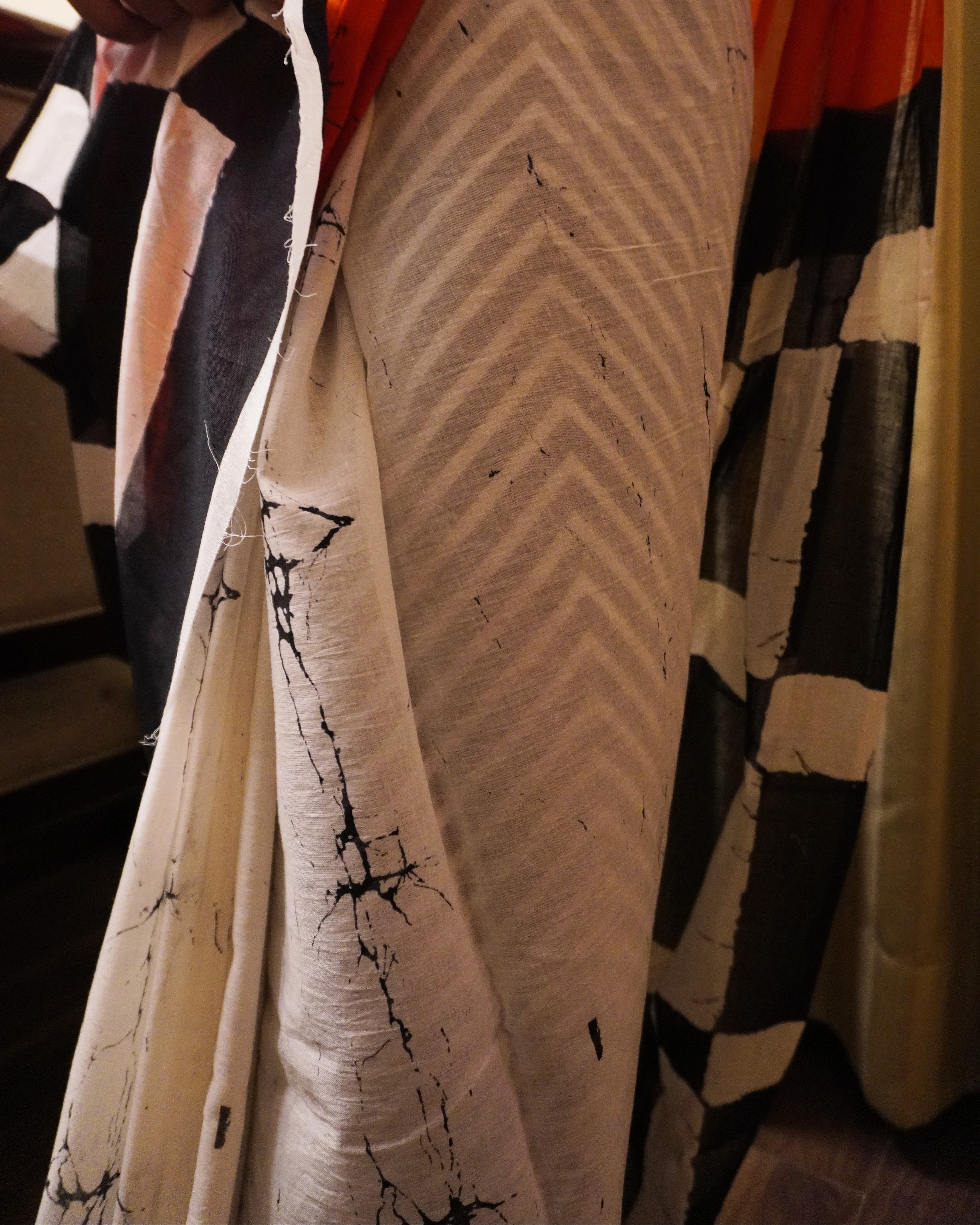 Close-up of orange, black and white plain cotton saree showing fabric texture and smooth finish