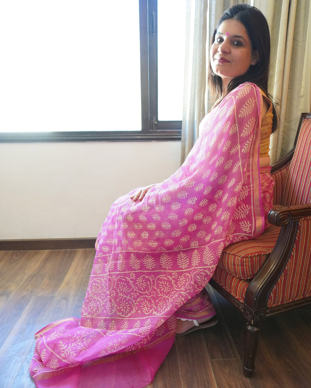 Side look of pink and beige leaf motif handblock print Kota Doriya saree displaying soft drape and border detail