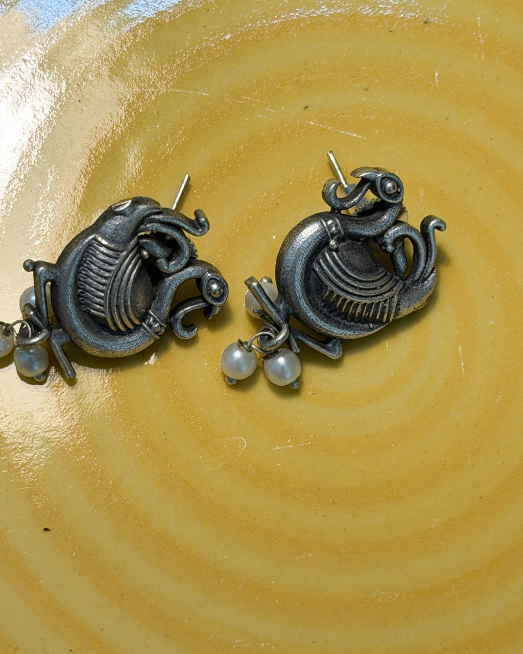 Matching peacock motif earrings with pearl drops in antique brass finish