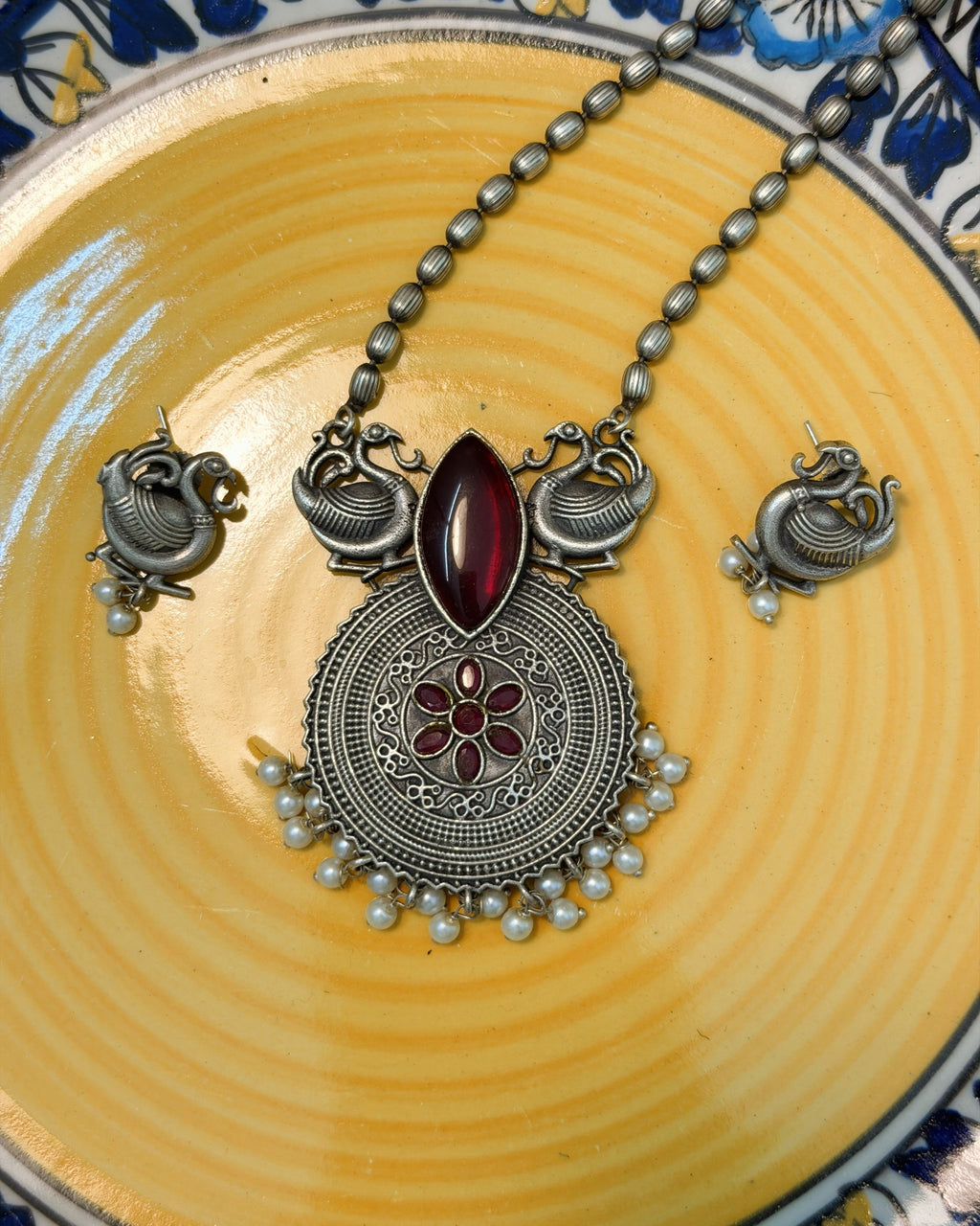 Antique brass peacock motif necklace set with deep red stone and pearl drops full view