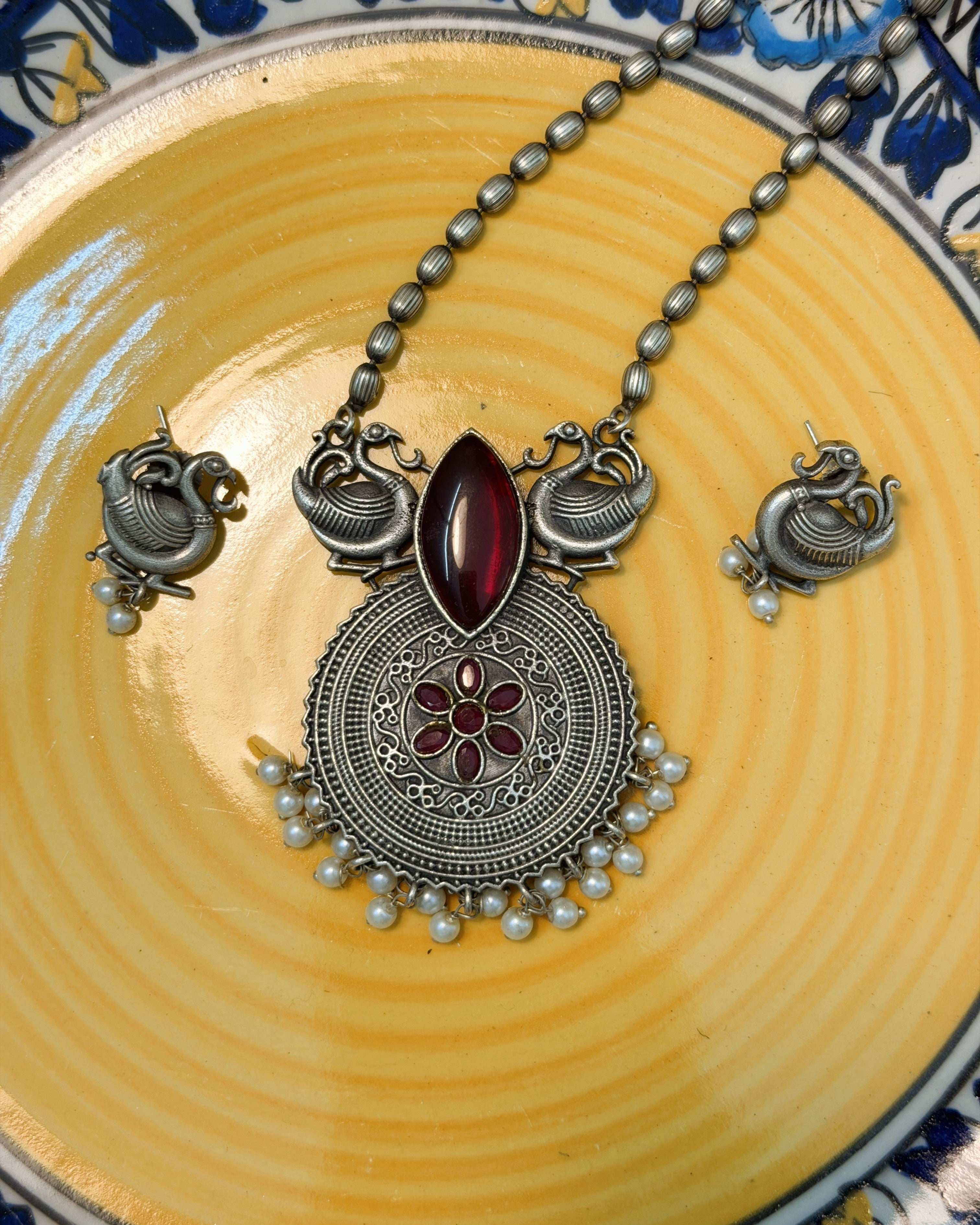 Antique brass peacock motif necklace set with deep red stone and pearl drops full view