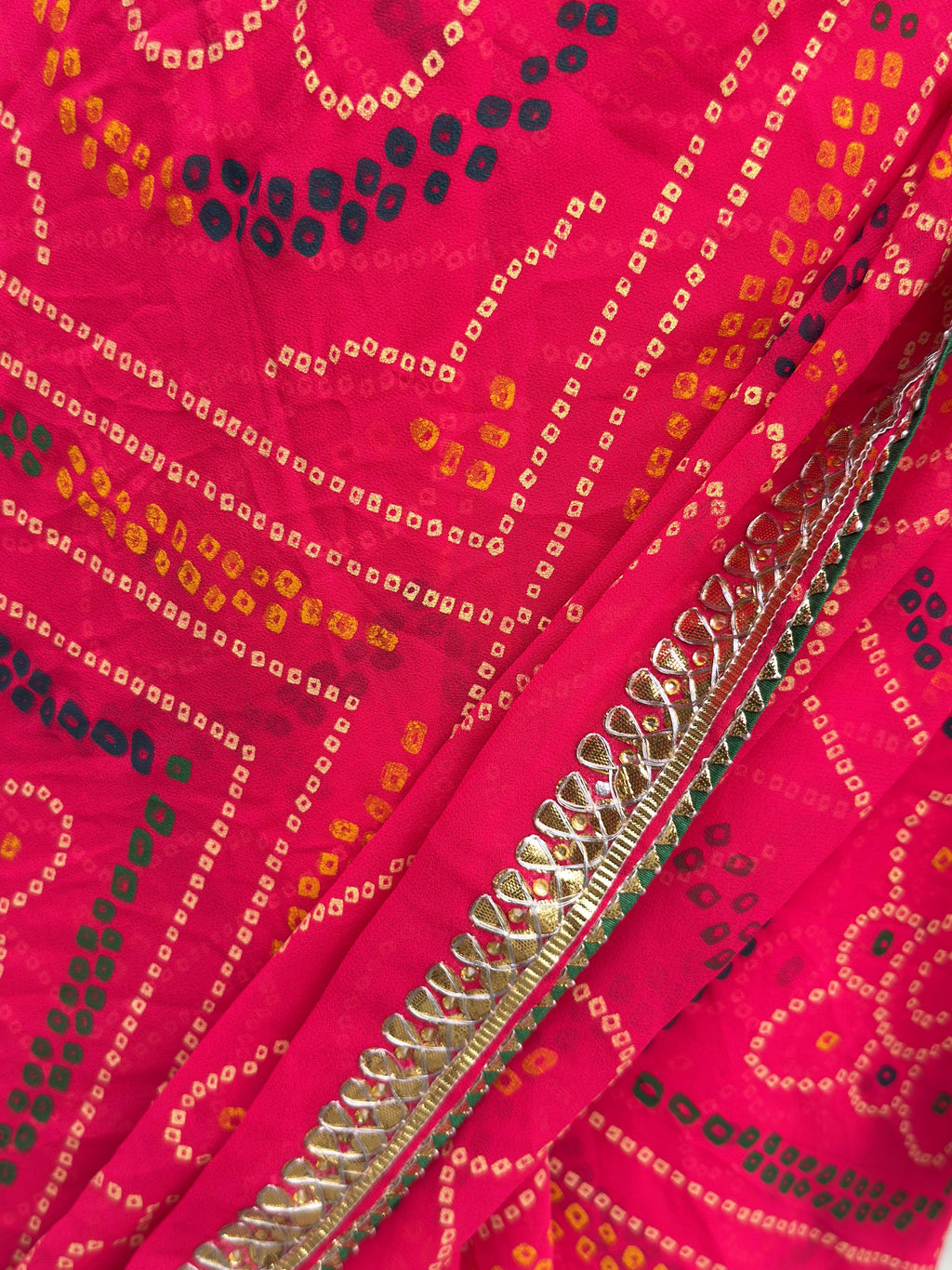 close up of bandhej print and gotta patti border on rani pink pure georgette saree