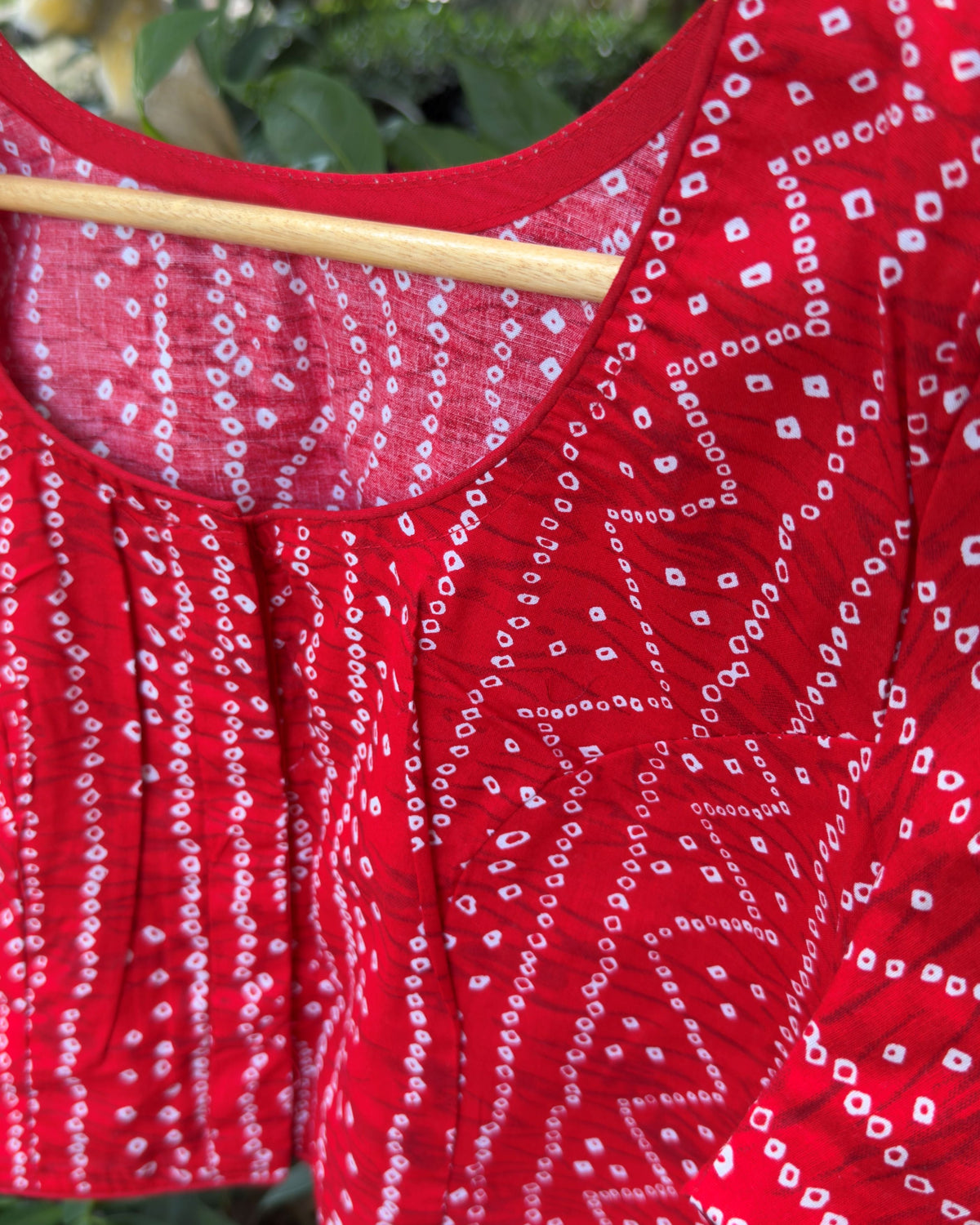 close up of red cotton fabric with white bandhej geometric dotted print