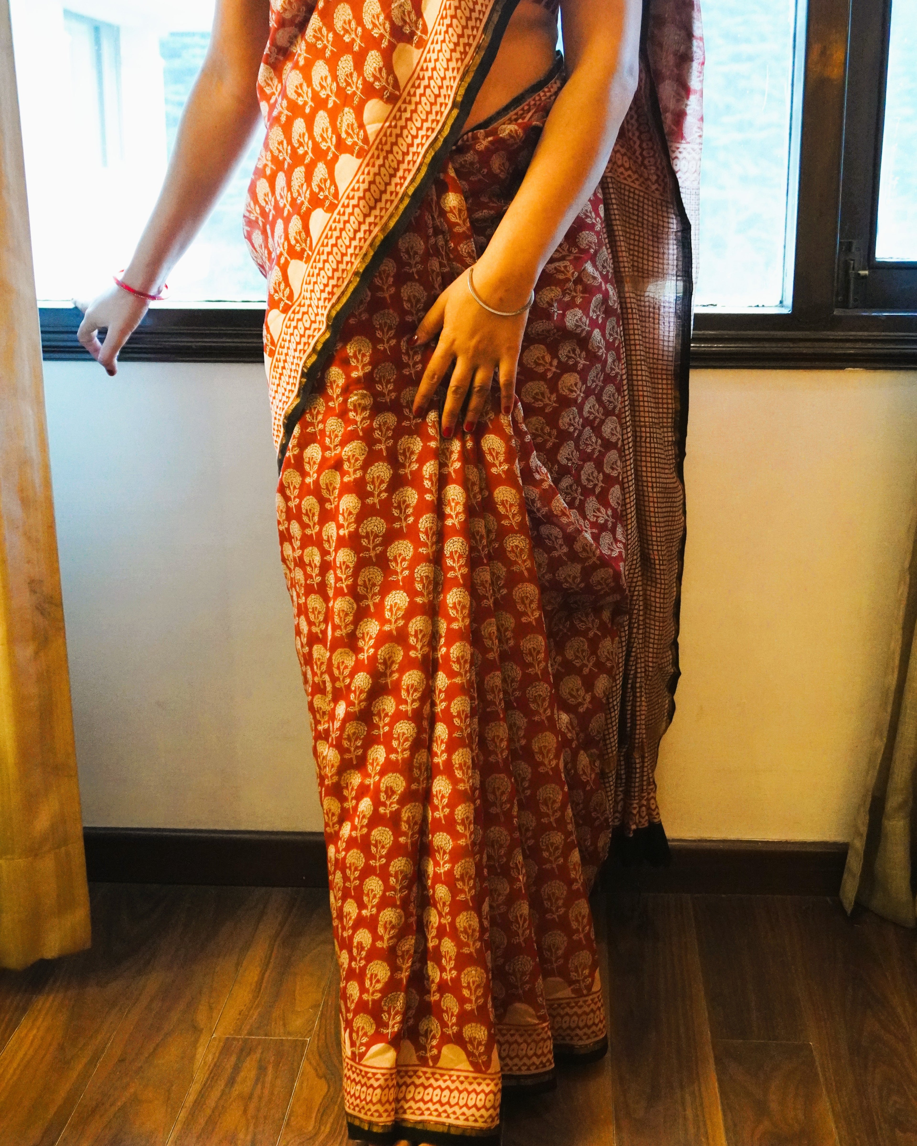 Close-up of rustic maroon Chanderi silk handblock Bagru print saree showing intricate handblock patterns and fine texture