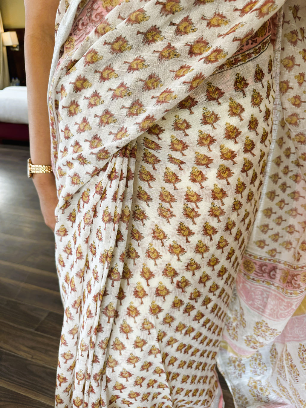 Fabric detail of white multicolour handblock leaf motif print pure linen saree highlighting traditional craftsmanship