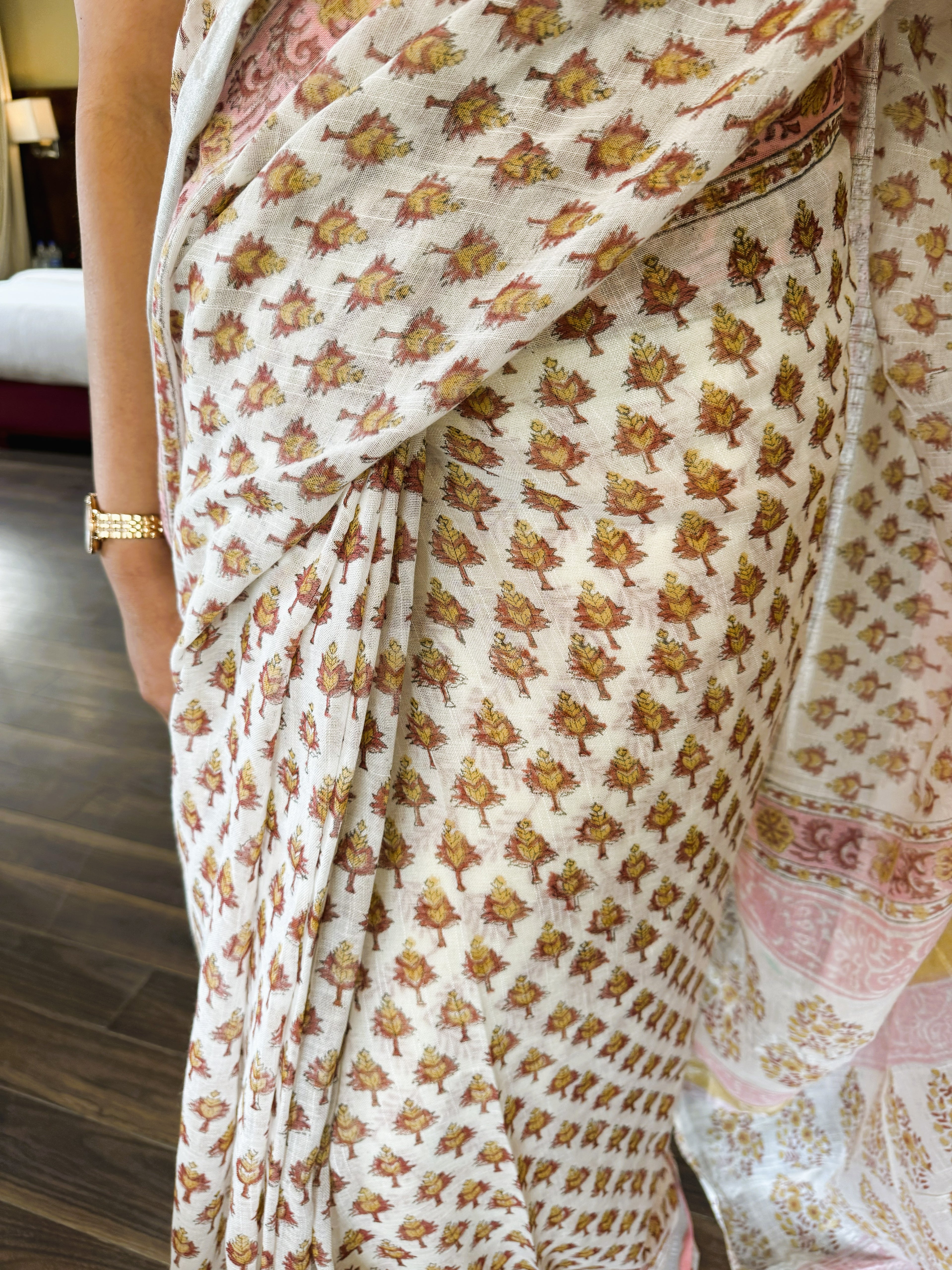 Fabric detail of white multicolour handblock leaf motif print pure linen saree highlighting traditional craftsmanship