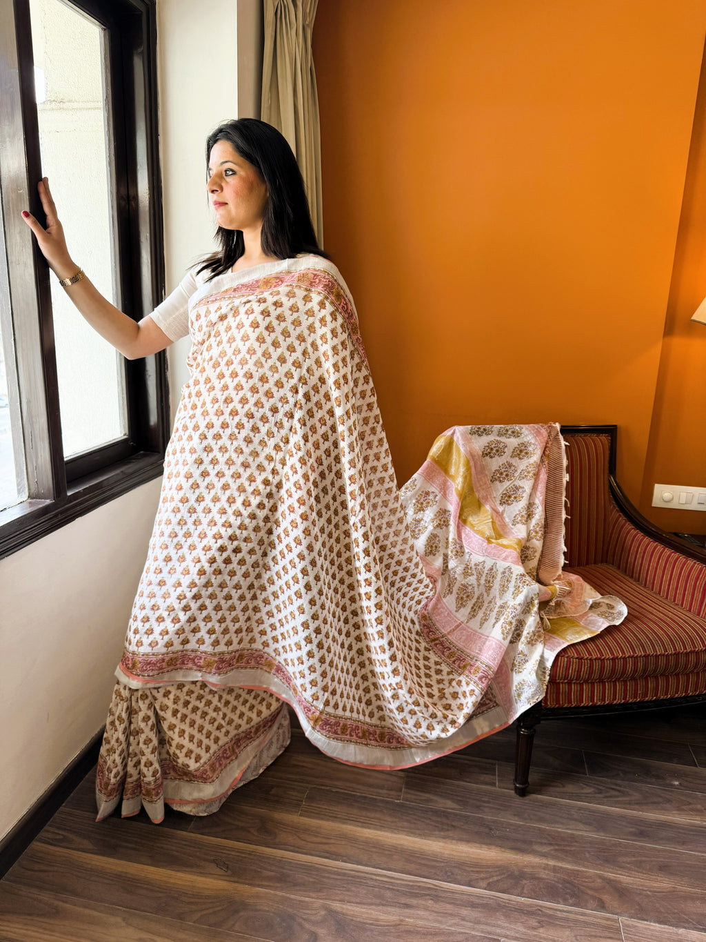 Side view of white multicolour handblock leaf motif print pure linen saree displaying drape flow and border detailing