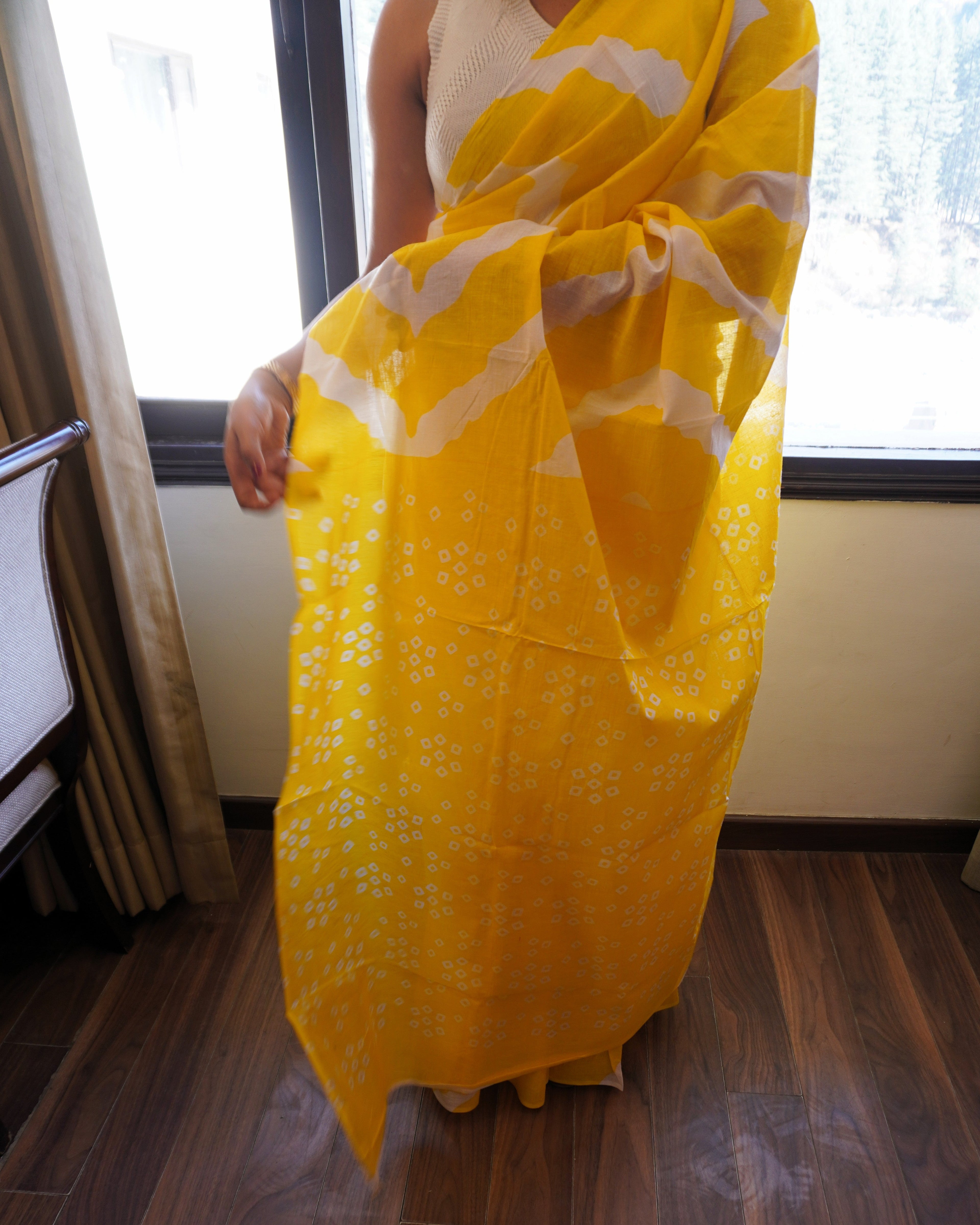 Close-up of yellow and white Leheriya cotton saree showing traditional wave pattern and fabric texture