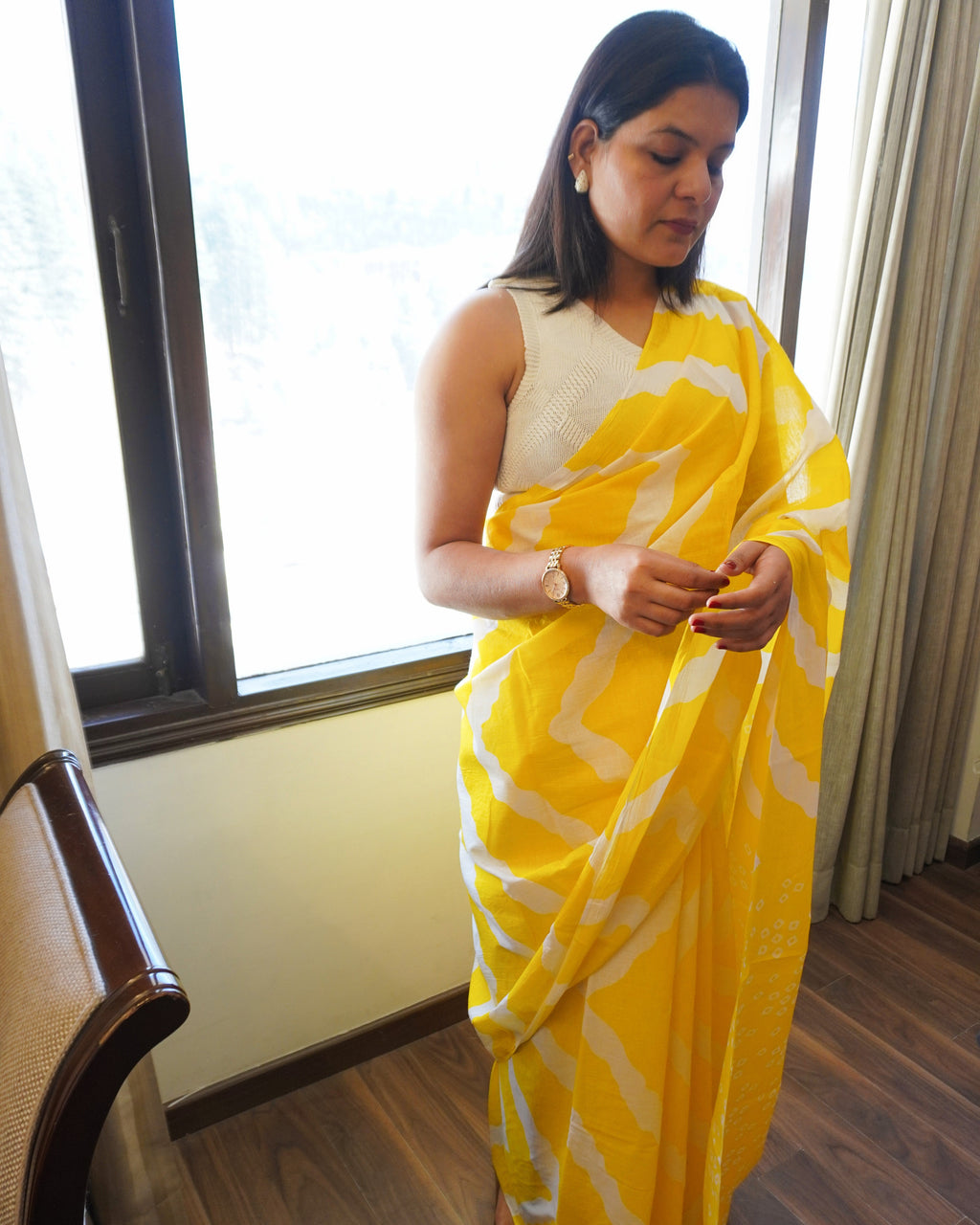 Side view of yellow and white Leheriya cotton saree displaying soft drape and border detailing