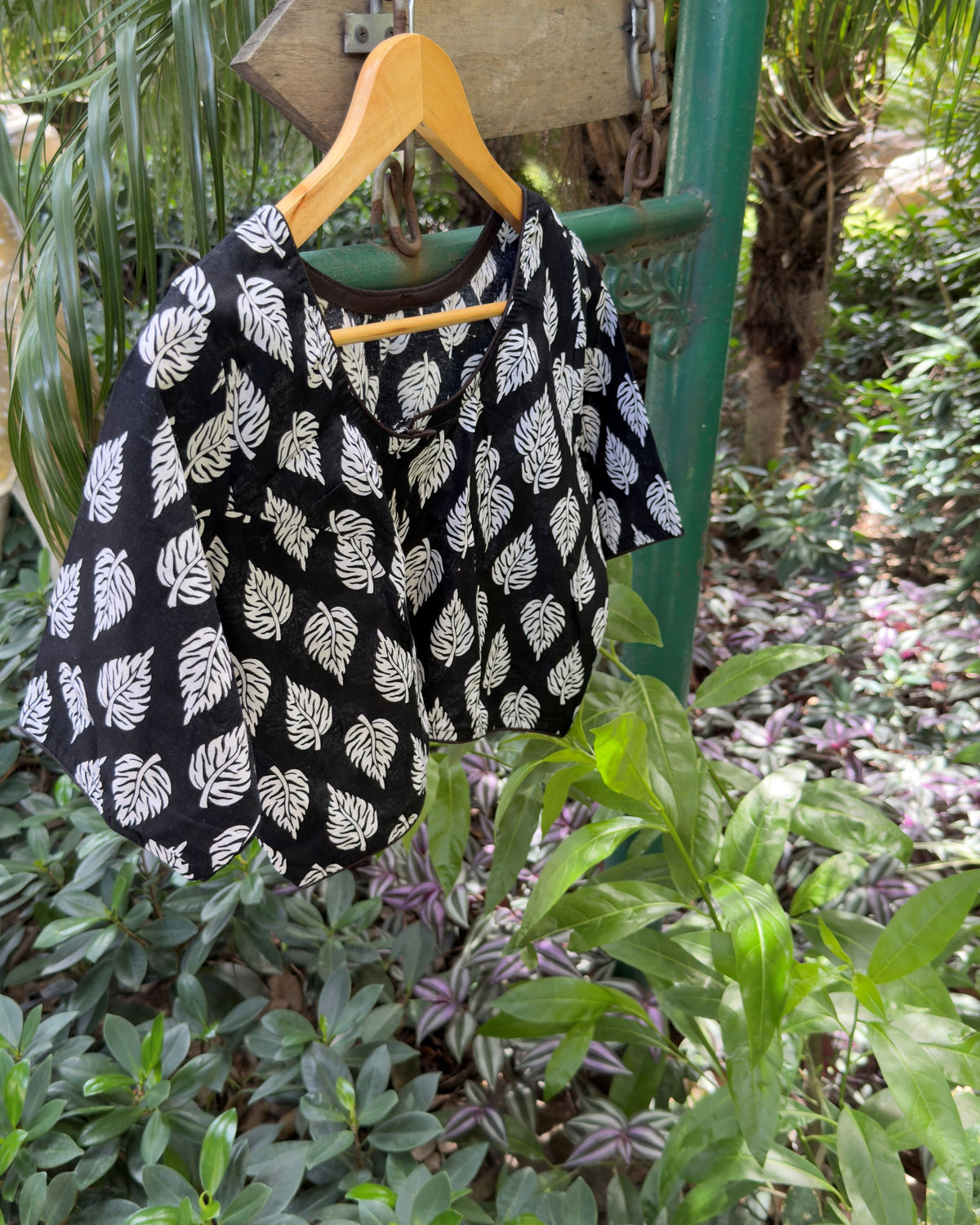 Detailed view of white botanical leaf motifs on black cotton blouse