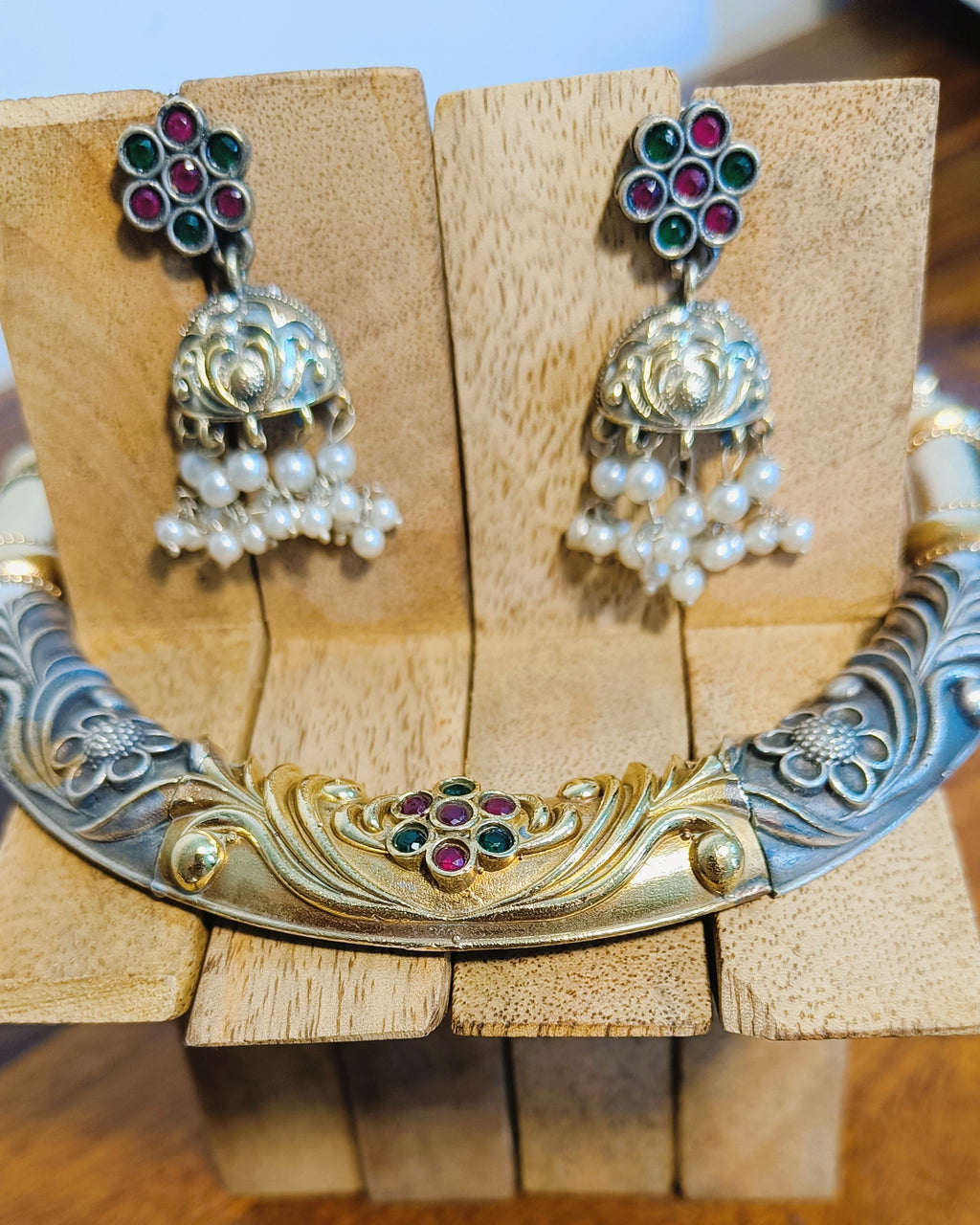 Detailed view of the gold-tone arch centrepiece of the Rajwada choker with ruby-red and emerald-green floral stone cluster