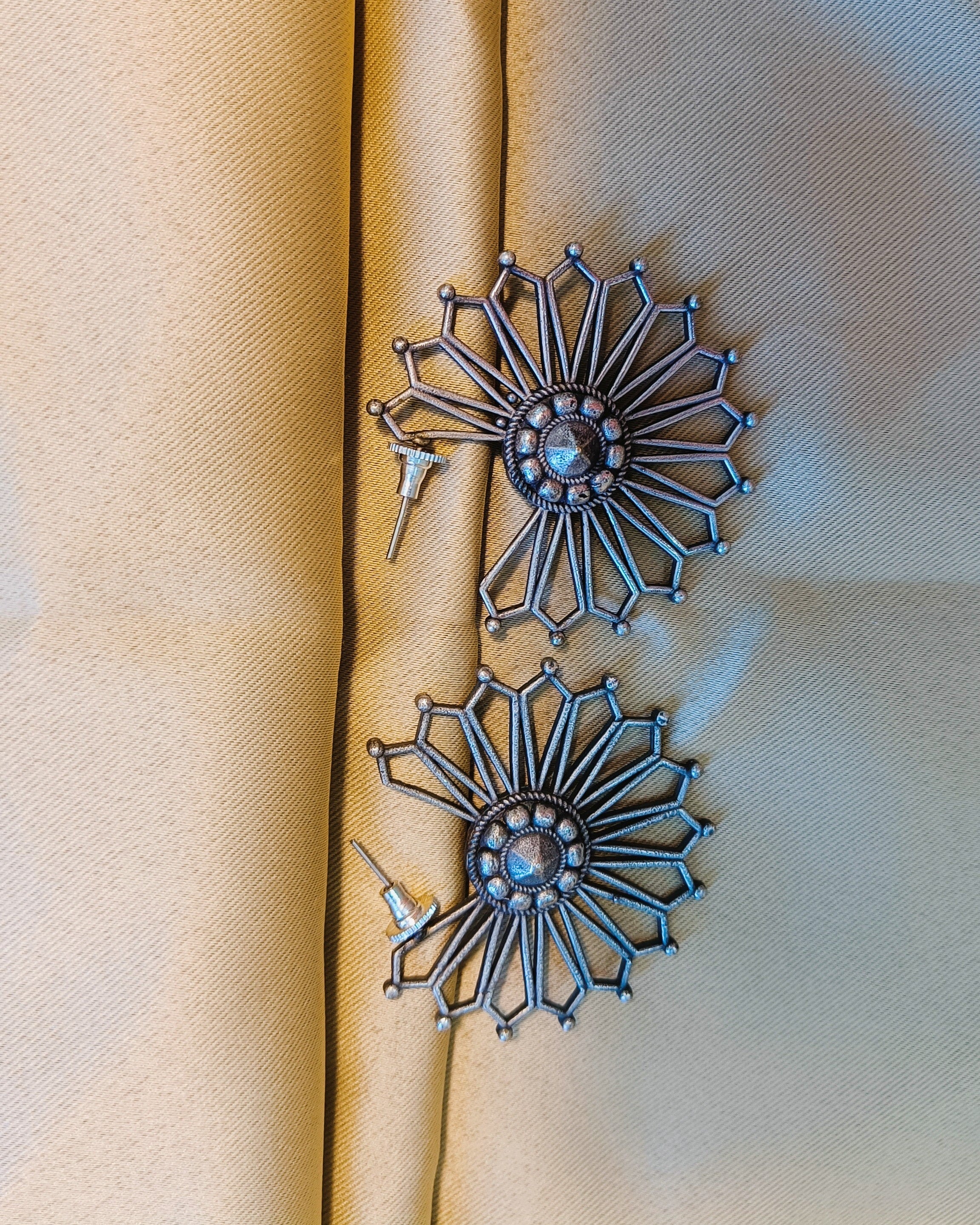 Detailed view of the domed centre boss with rope-twisted border and raised bead detailing of the Surya Chakra sunburst stud earring