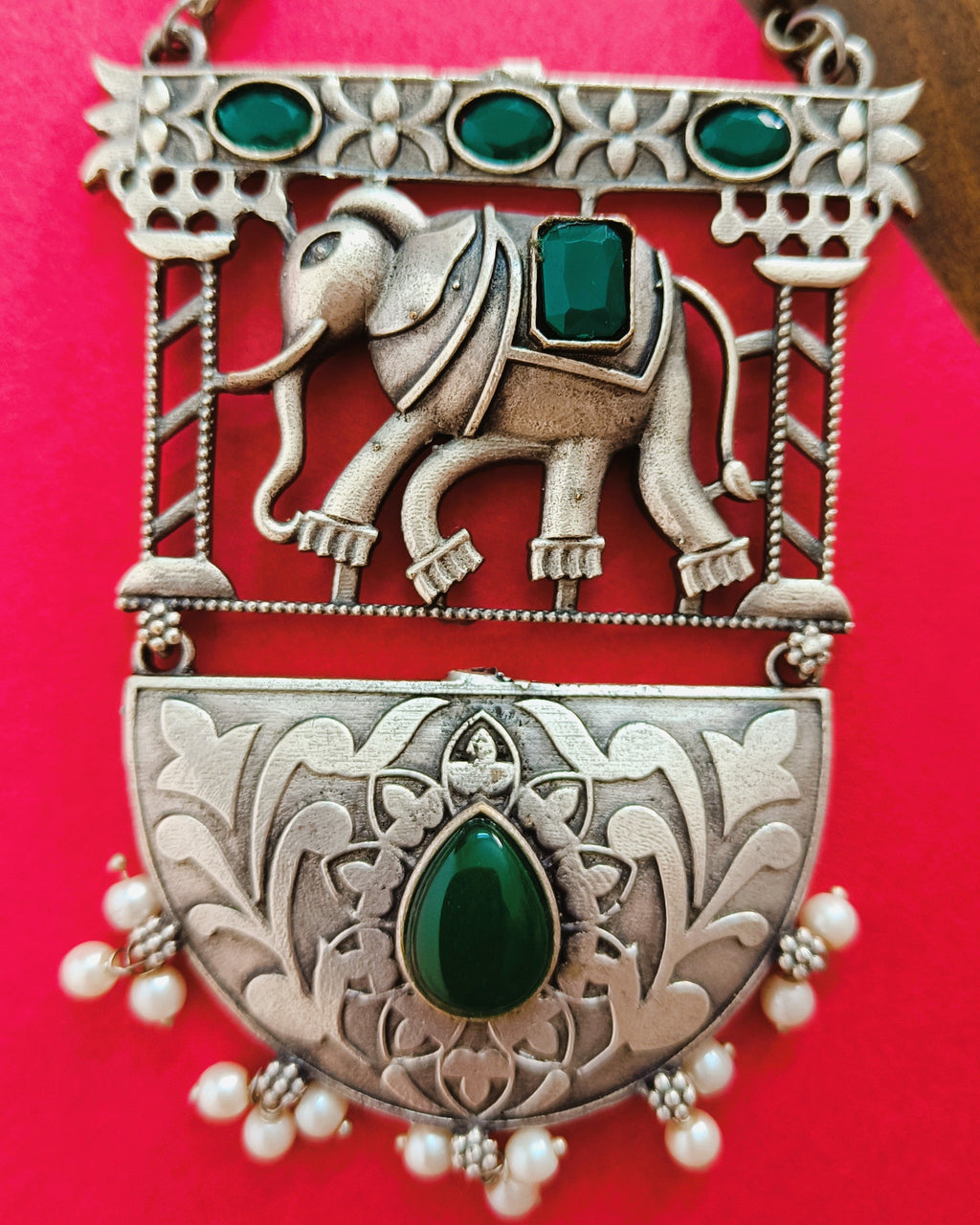 Close-up of the majestic elephant sculpted in high relief within the ornate arch frame with emerald-green stones and floral engraving