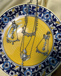 Ganesha Bloom oxidised silver necklace and earrings set displayed on a yellow ceramic plate with blue floral border