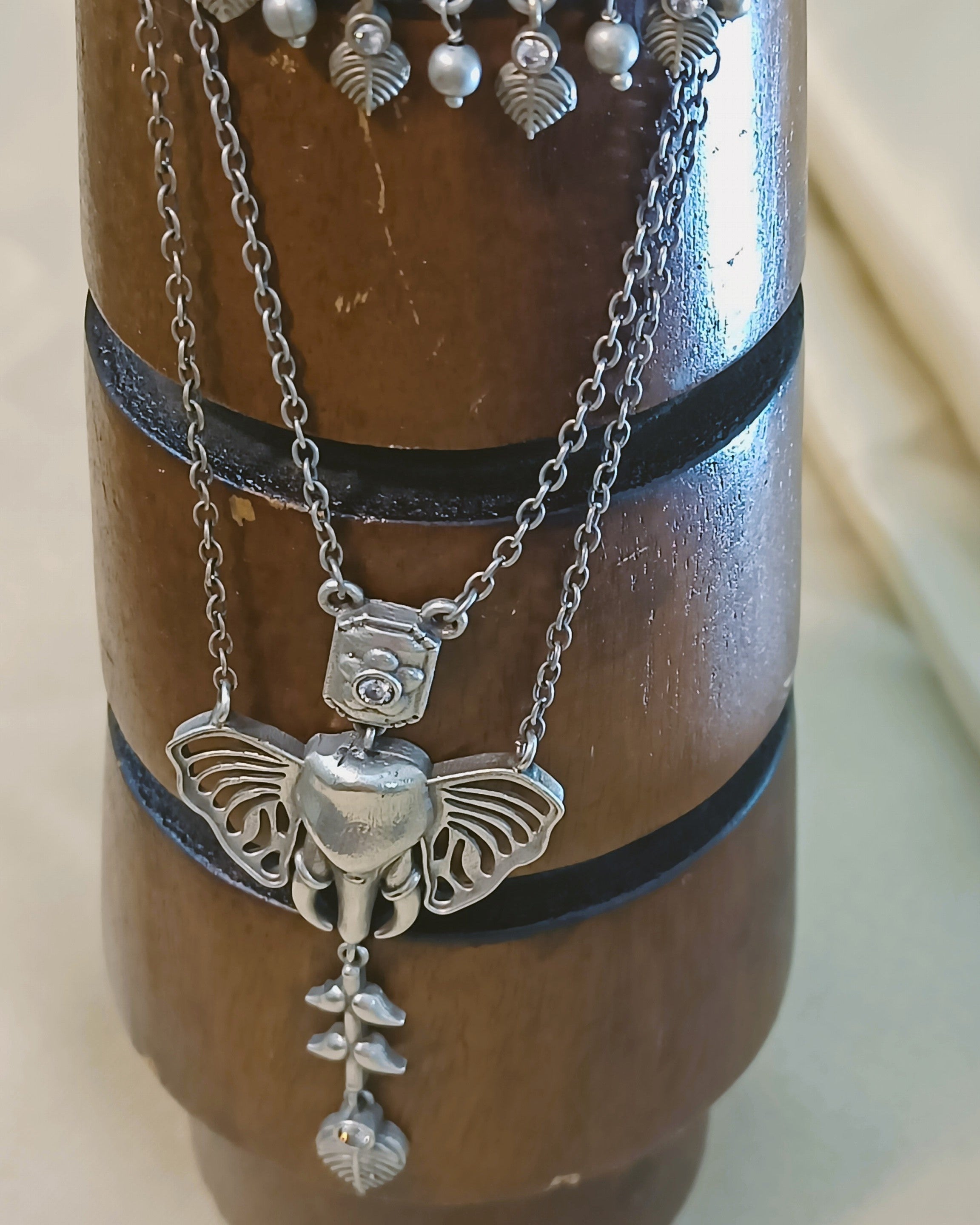 Silver Ganesha drop earrings with crescent arch, leaf charms, and crystal accent stones