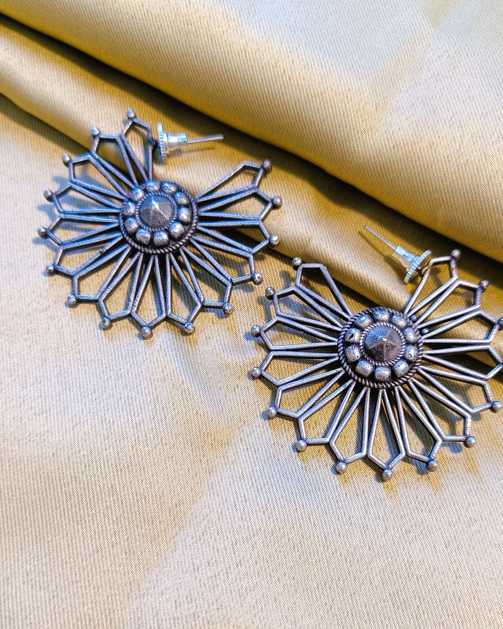 Close-up of the hexagonal ray frames and tiny ball finials at the tips of the Surya Chakra oxidised silver sunburst earring