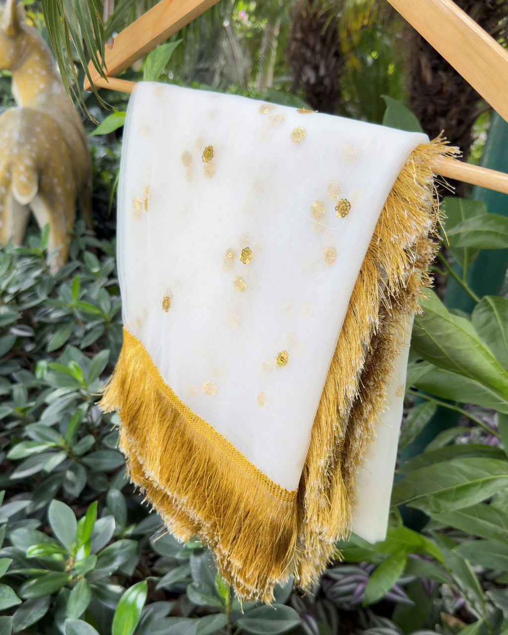 Detailed view of golden floral embellishments on sheer net fabric