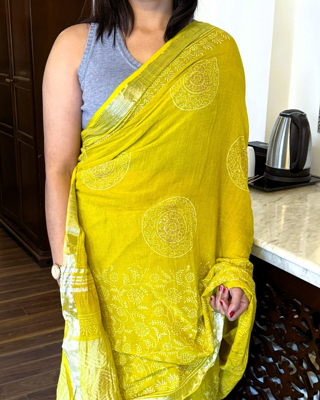 Close up of golden print on green pure linen saree fabric