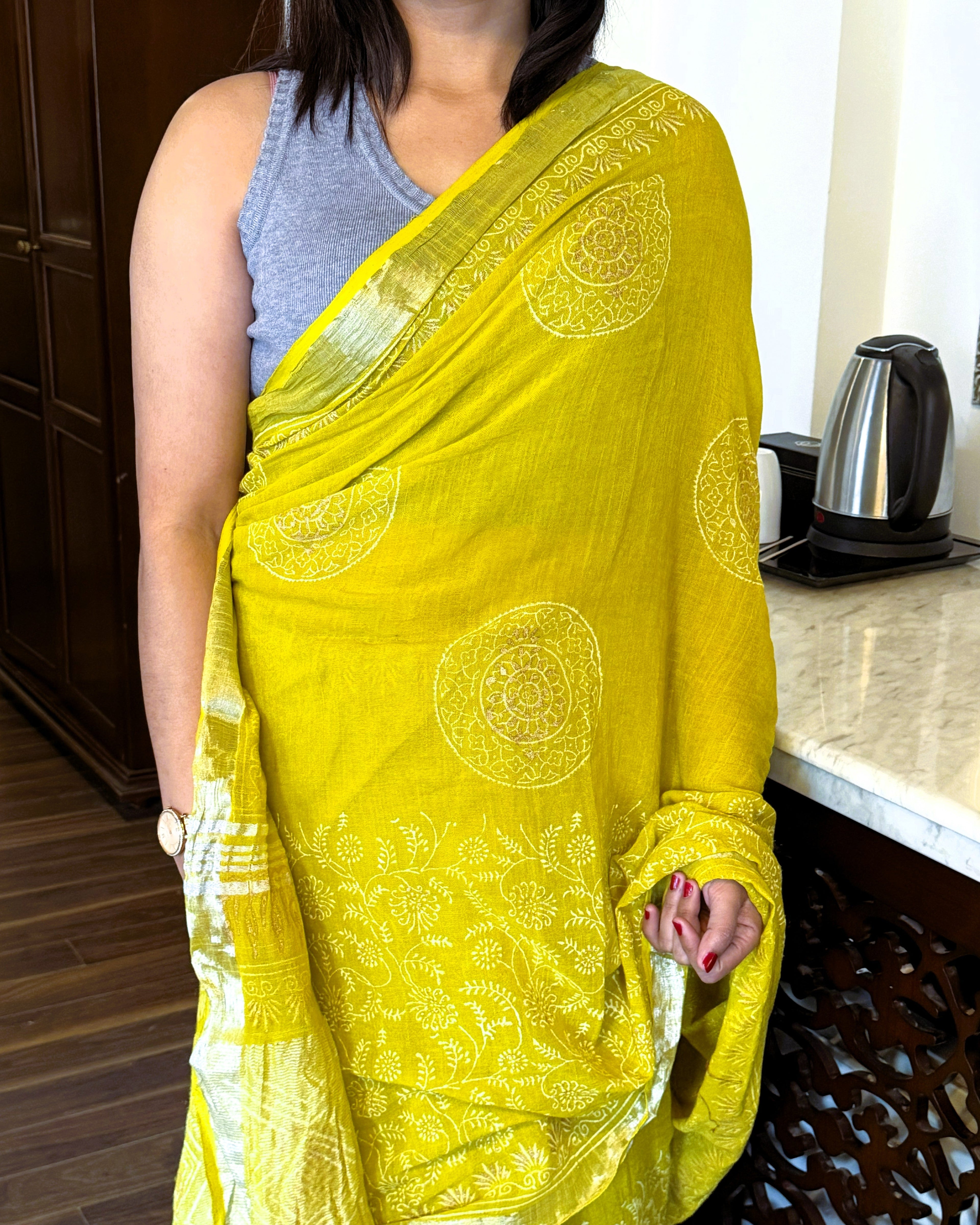 Close up of golden print on green pure linen saree fabric