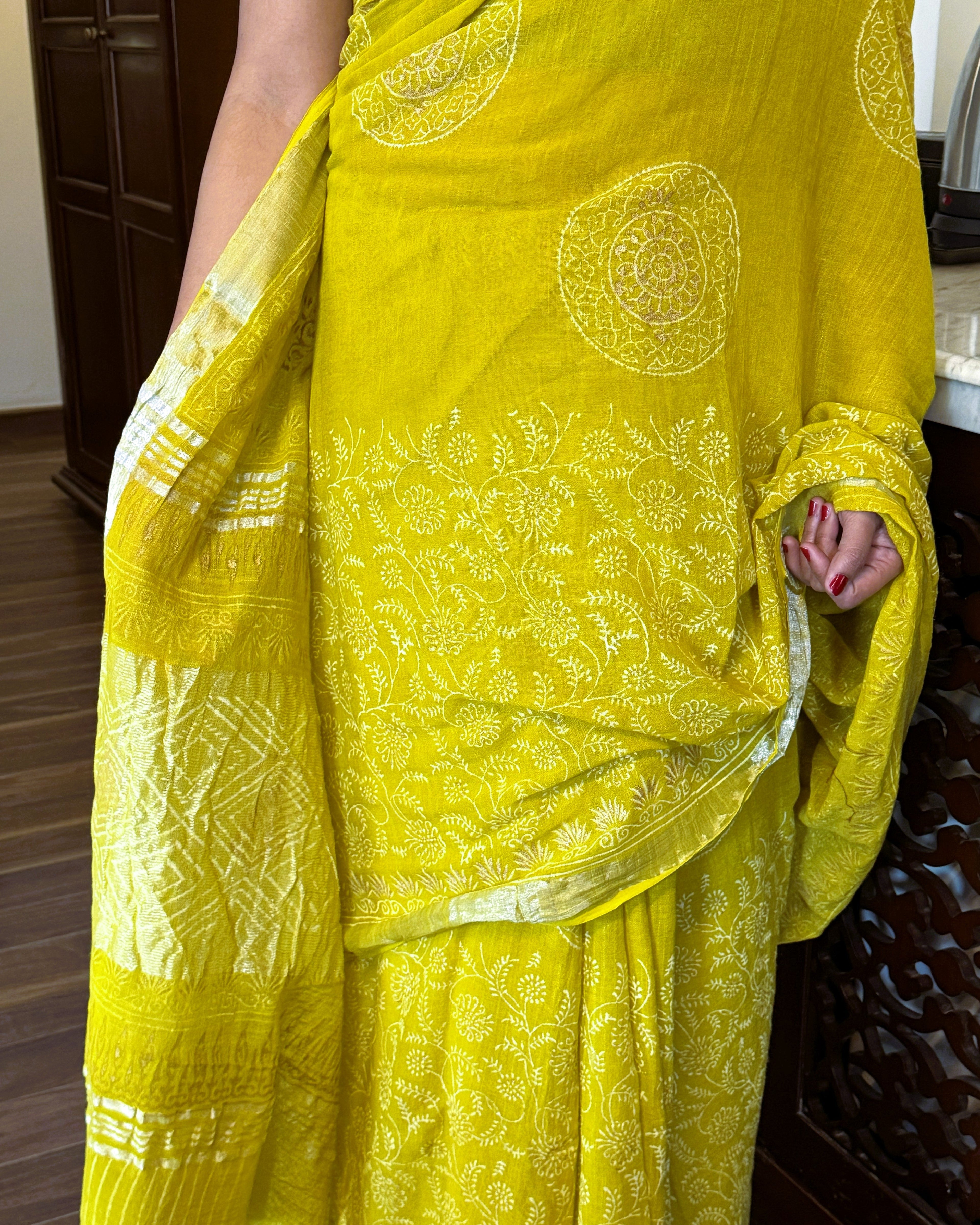 Detailed view of golden print pattern on green linen saree