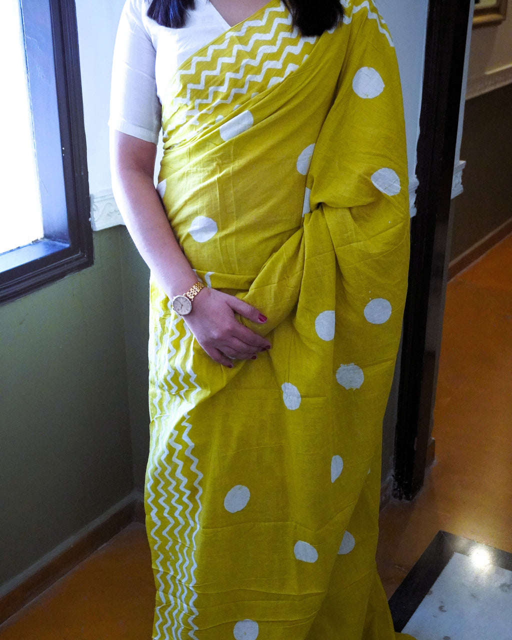 Close up of white polka dot pattern on green cotton saree