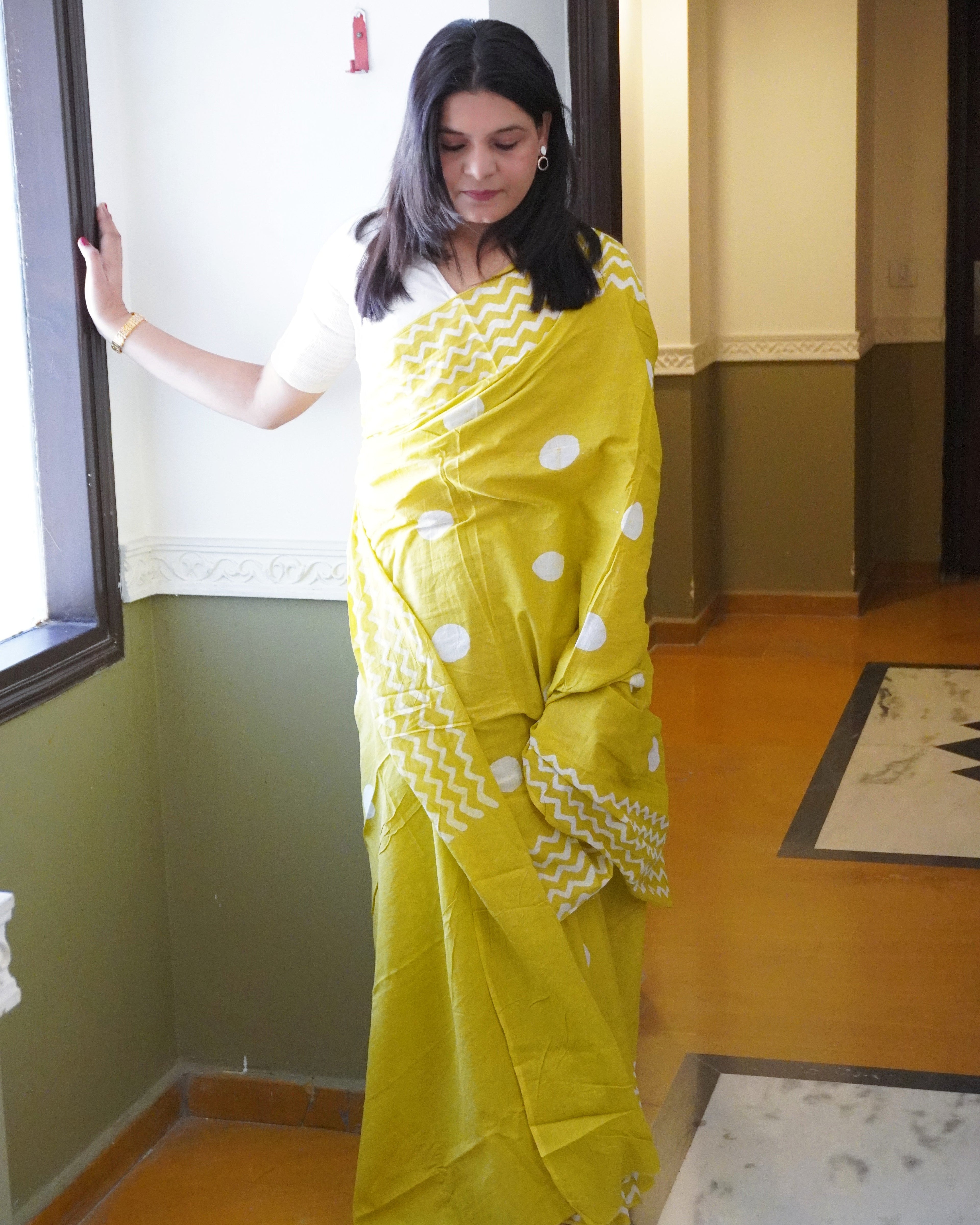 Front view of green cotton saree with white polka dot pattern