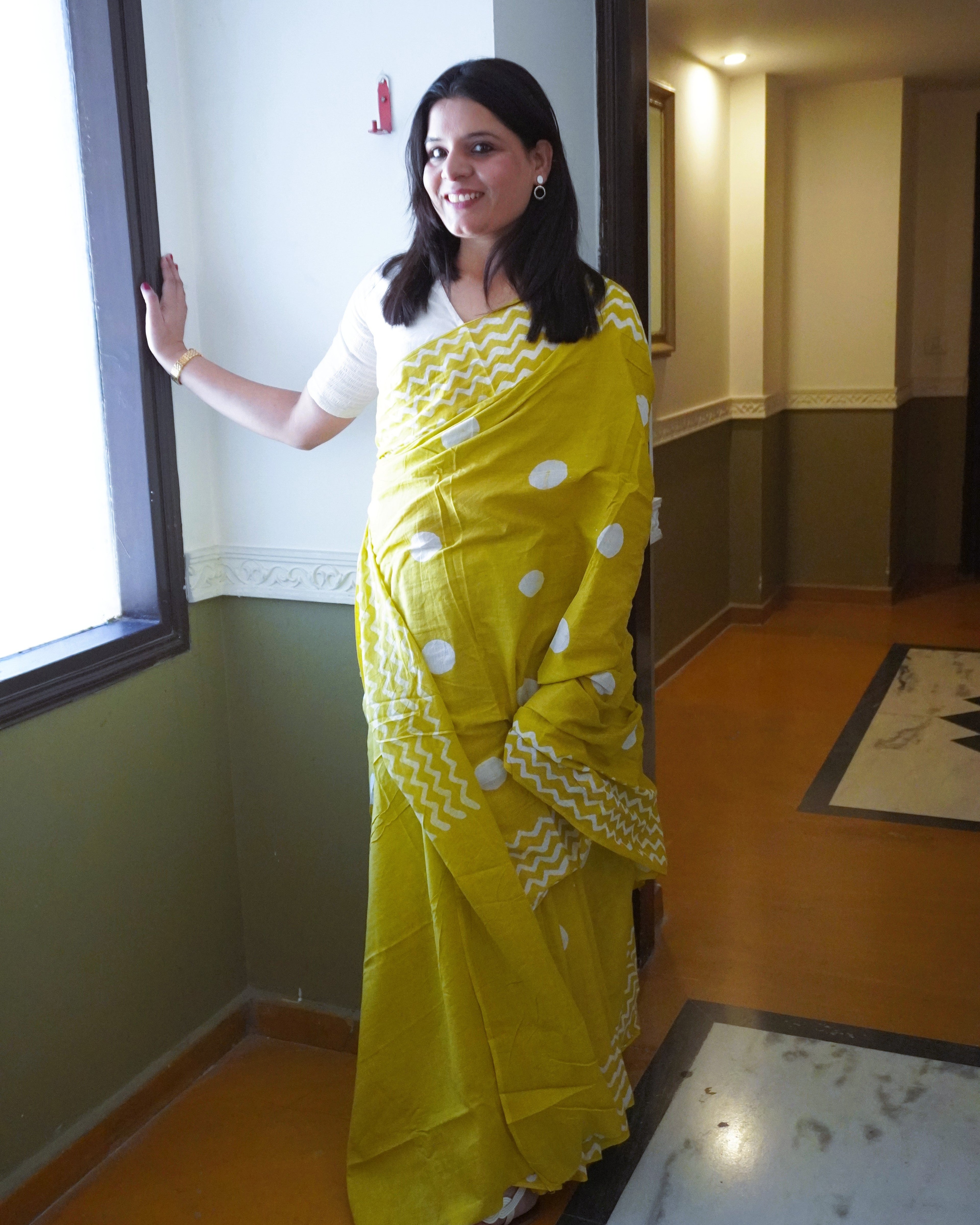 Front view of green cotton saree with white polka dot pattern