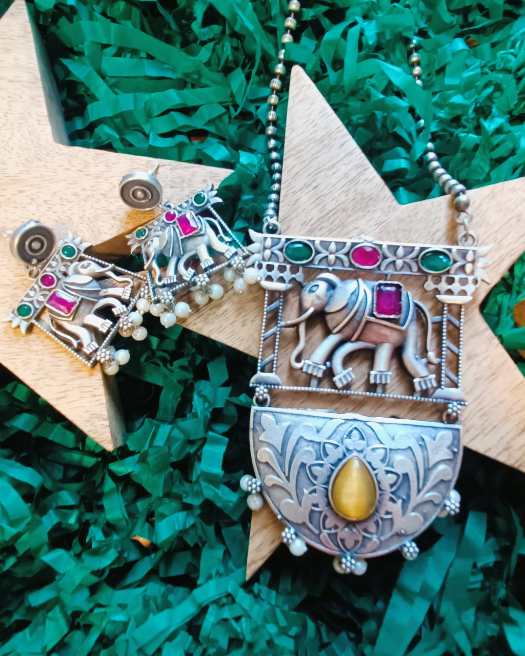 Hathi Raja elephant pendant necklace set styled with ethnic wear, showcasing the antique oxidised silver finish and coloured stones