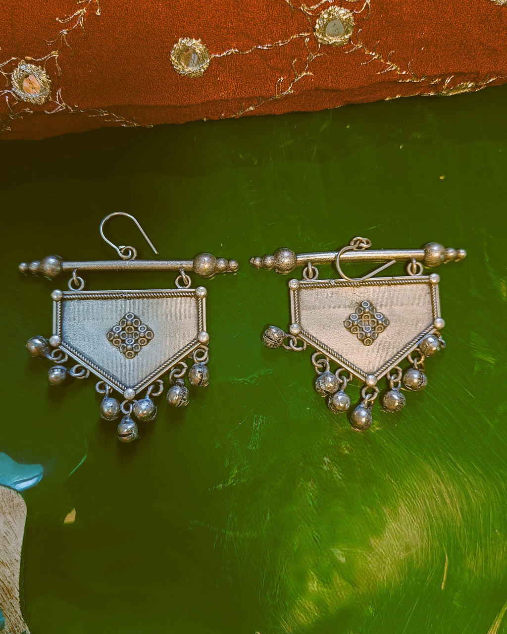 Khanjar shield drop earrings in antique brass silver styled with ethnic wear showcasing the tribal geometric silhouette and ghungroo drops