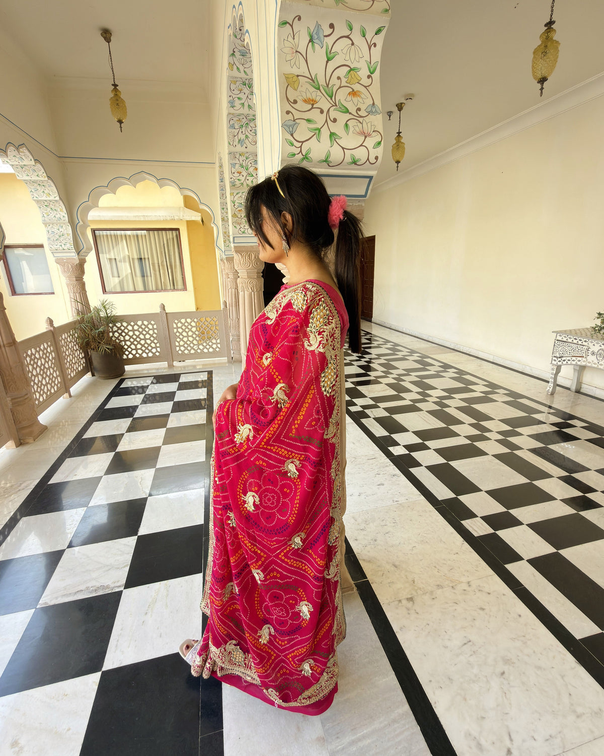 Close-up of Zari work and colourful Bandhani-inspired pattern on magenta saree