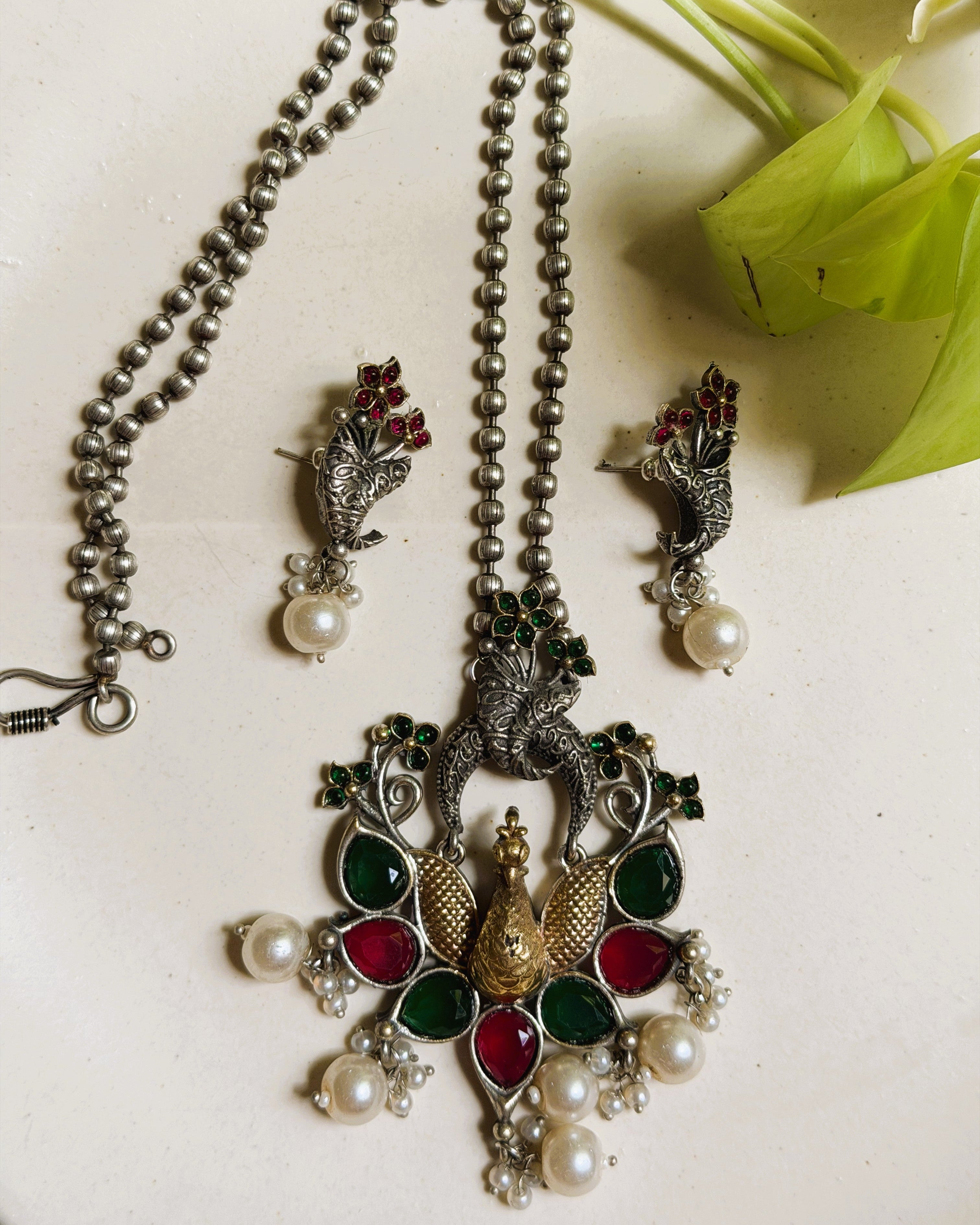 Traditional oxidised peacock necklace set with red green stones and pearl accents
