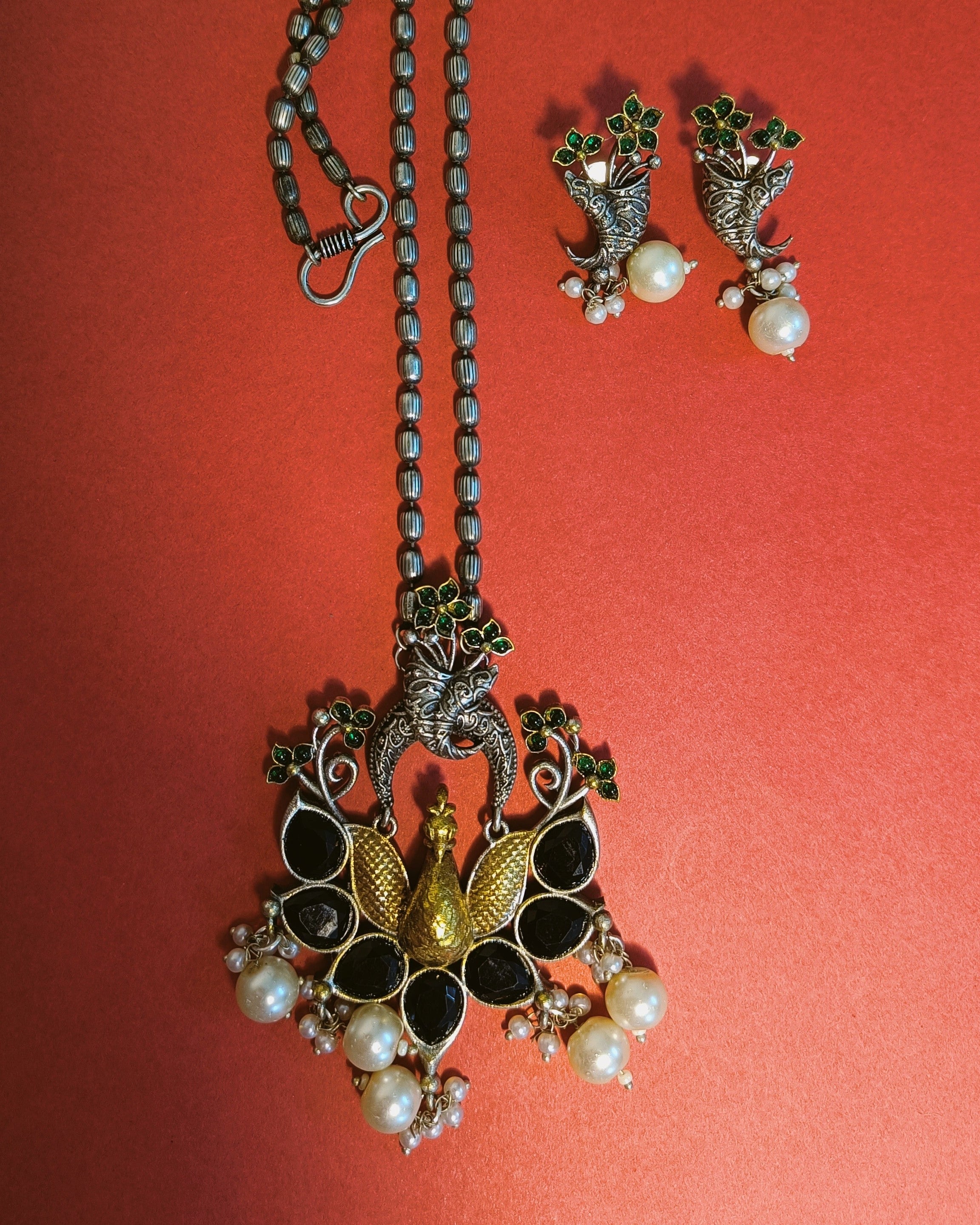 Mayuri Noir peacock long necklace and earrings set styled with ethnic wear showcasing the dual tone oxidised silver and gold finish