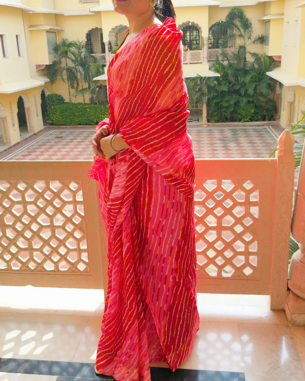 Woman wearing multi red shade lehriya semi kota doria saree, draped look for festive occasions