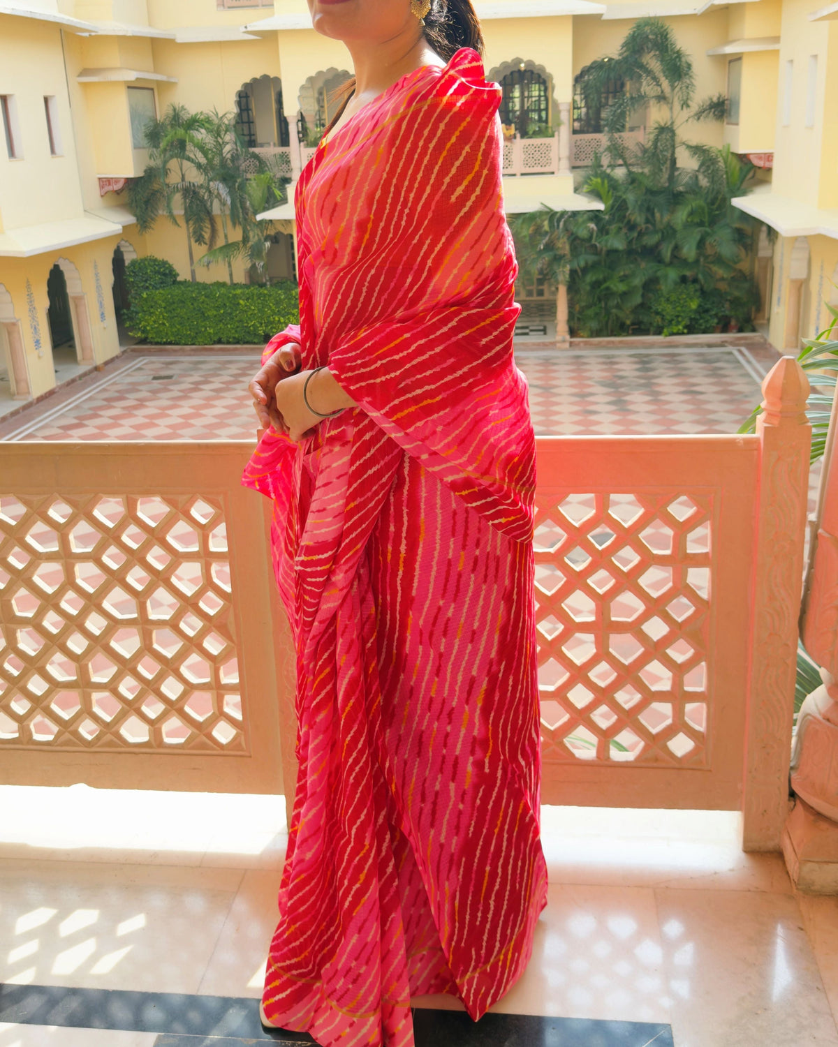Woman wearing multi red shade lehriya semi kota doria saree, draped look for festive occasions