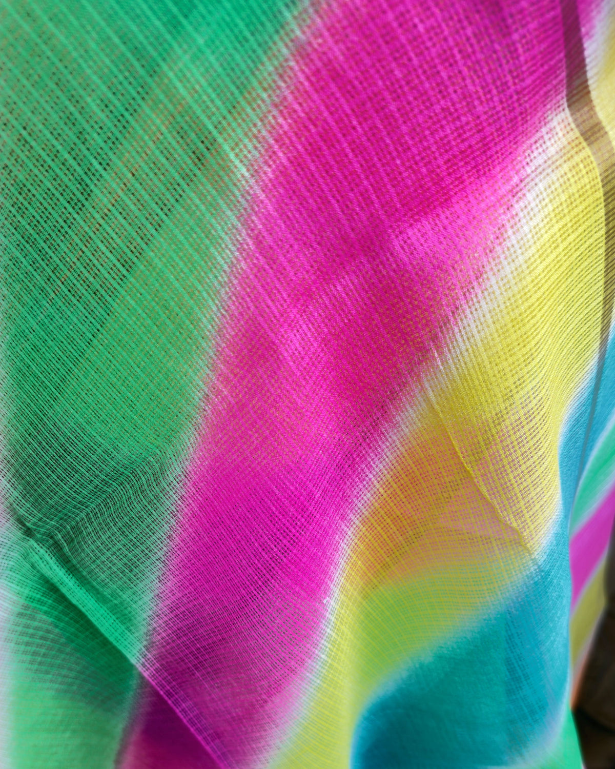 Close-up of diagonal lehriya waves in green, pink, yellow, and blue on kota doria fabric