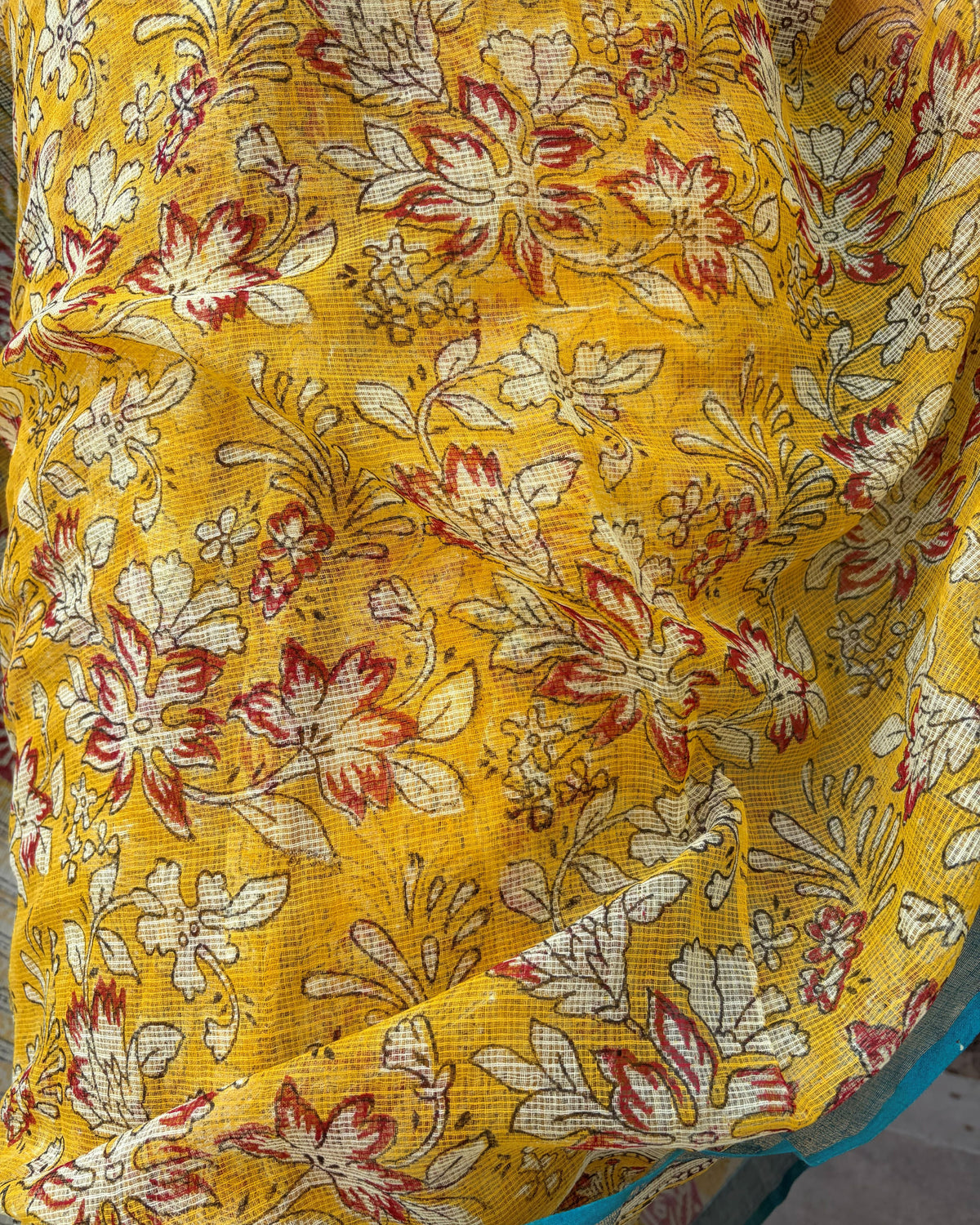 Mustard yellow floral print Kota Doria saree showing its lightweight drape
