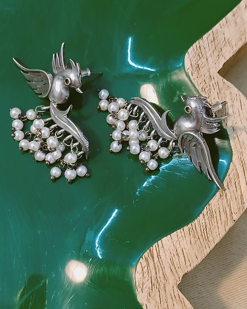 Statement earrings with bird shape and flowing pearl drops