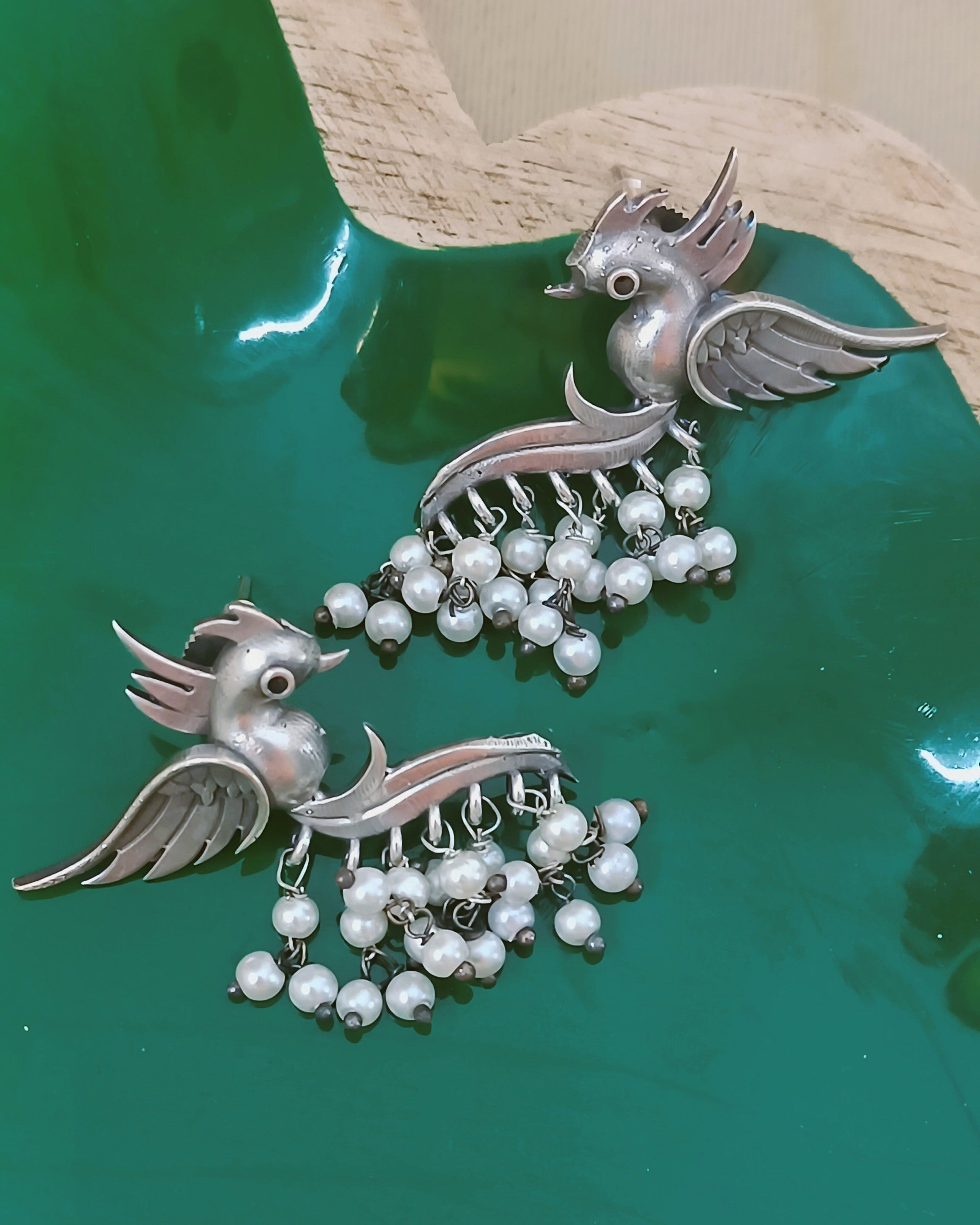 Traditional earrings with artistic bird motif and pearl detailing
