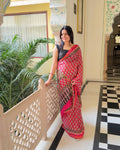 Pink zari cotton saree with black and teal leaf motif print and golden zari border, full front view