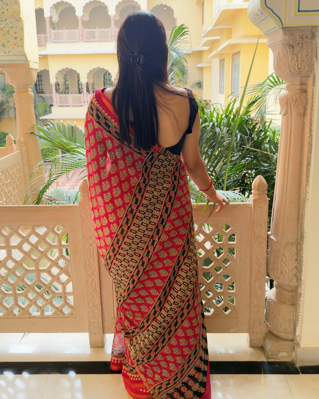 Printed pallu of pink zari cotton saree with floral border in black and cream