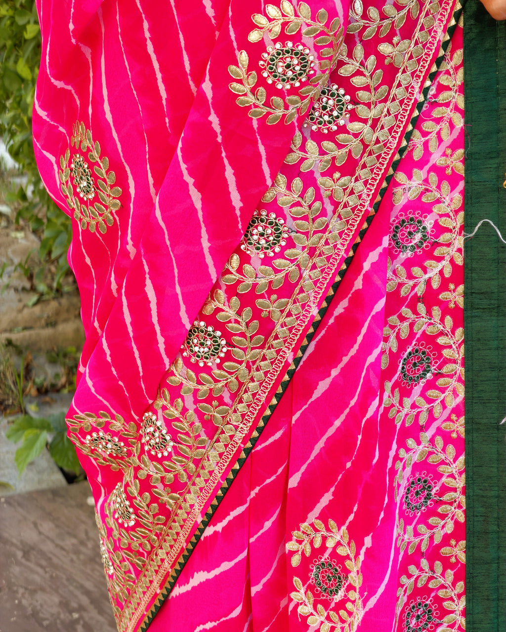 Close-up of floral and leaf Gotta Patti detailing on magenta Lehariya saree