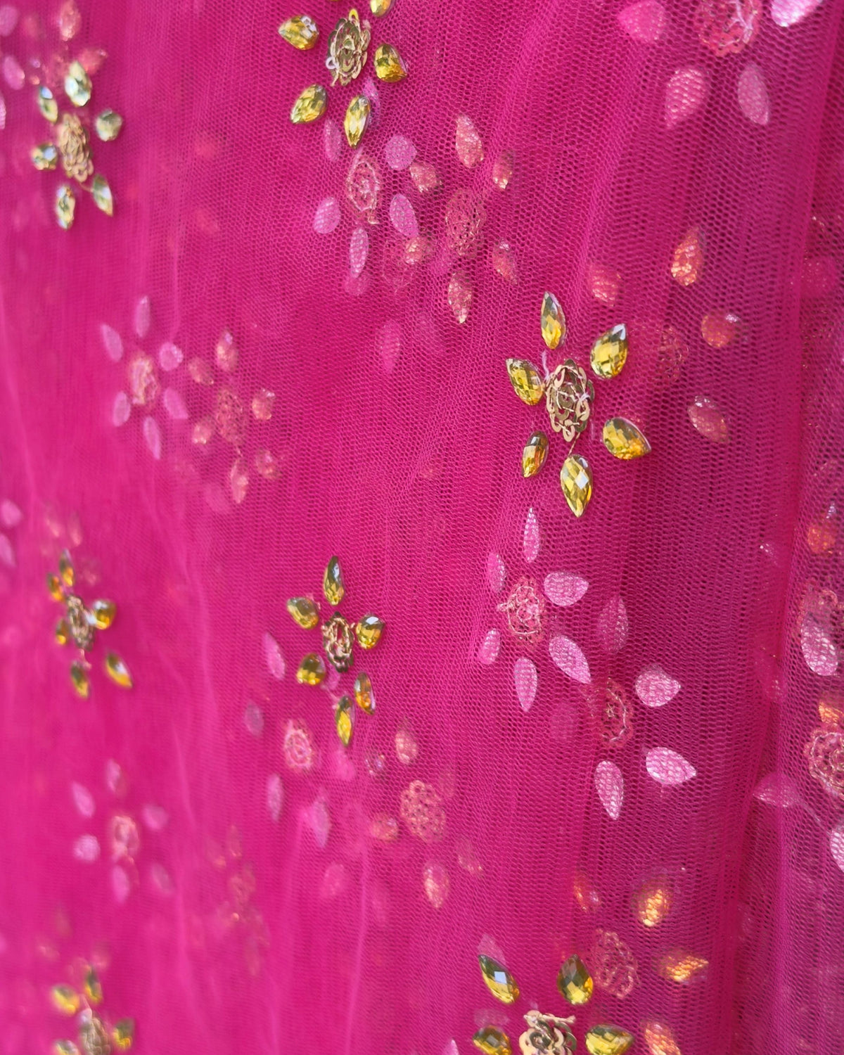Close-up of pink net dupatta featuring golden floral detailing