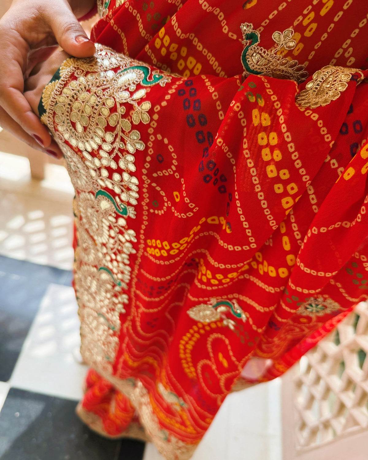 Close-up of Bandhani print and Gotta Patti work on red saree